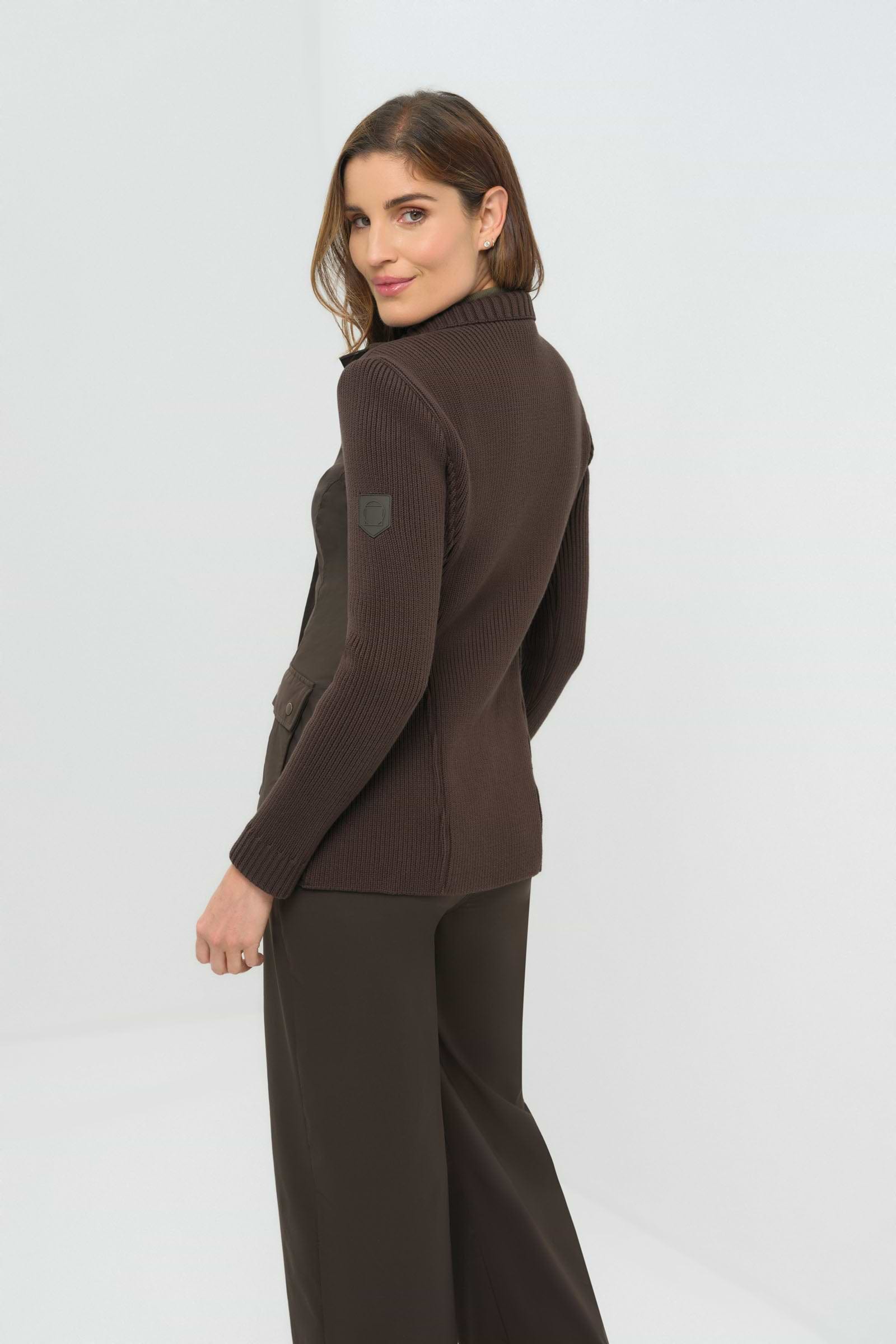 Front view of olive green jacket featuring  knitted back and side.