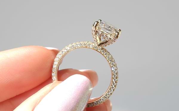 woman holding a diamond ring with a pave band
