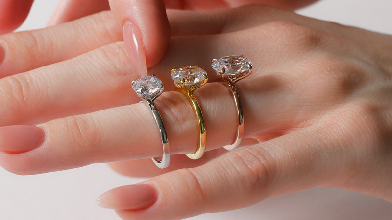 Platinum, yellow gold, and rose gold rings on finger