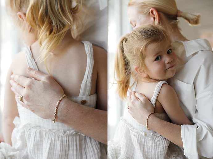 woman wearing an Anne Sage x Plum Diamonds perfect tennis bracelet holding her daughter