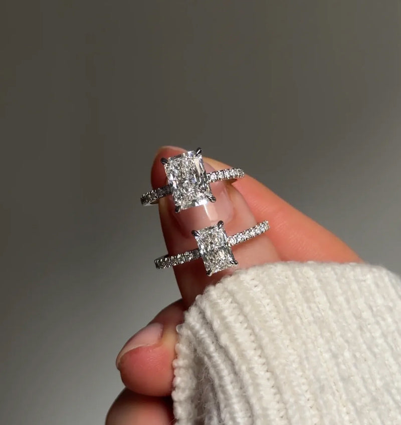Hand holding Radiant Cut Pave rings in different carat sizes 