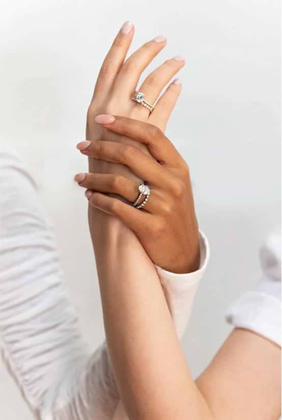 two intertwined hands wearing lab grown diamond rings