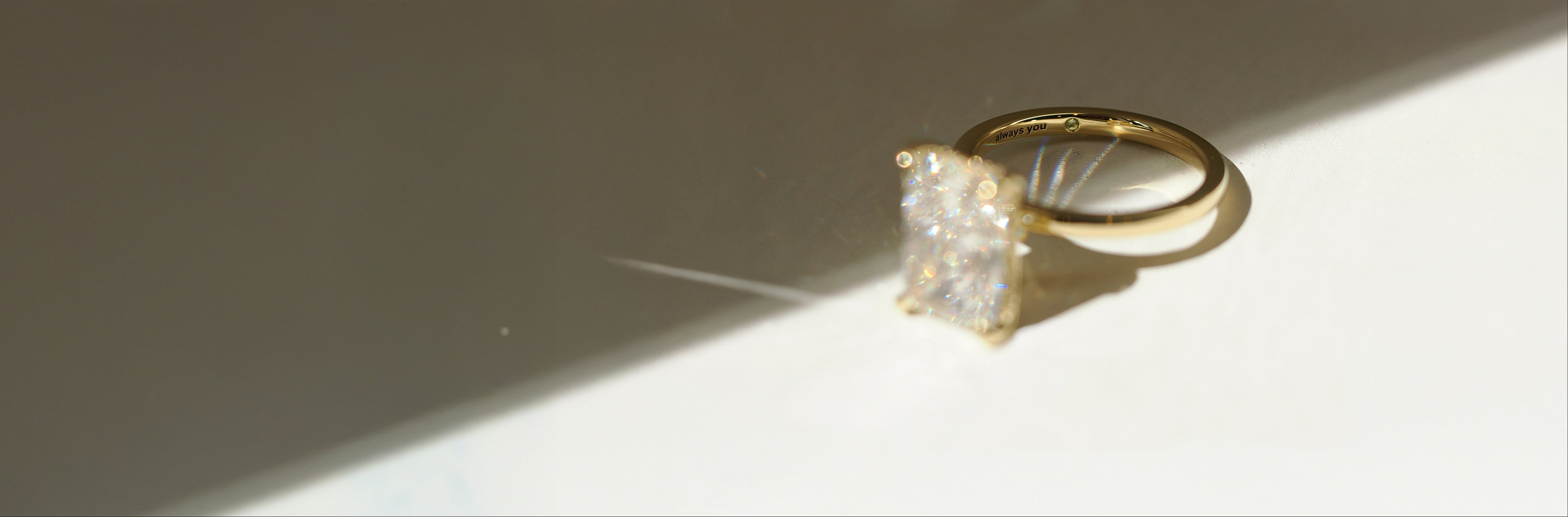 Gold ring with a large diamond on a reflective surface