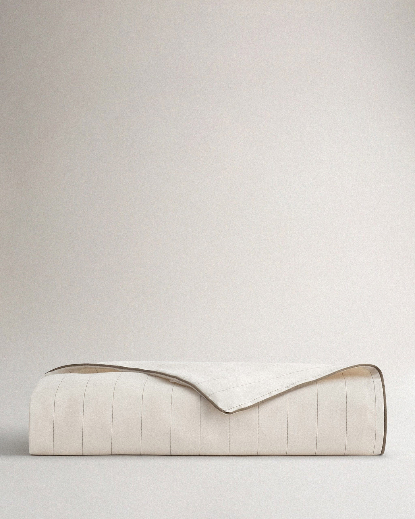 Image 1 of 2 showing Rise & Fall's sateen cotton duvet cover in buttermilk stripe.