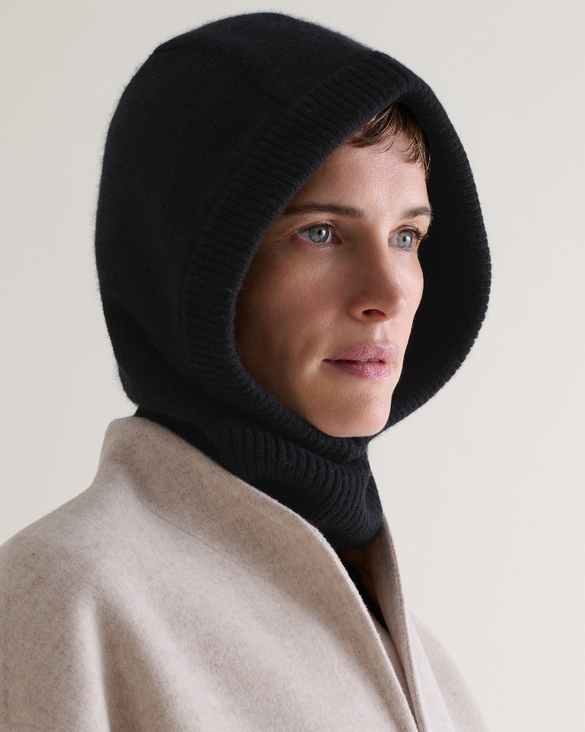 Image 1 of 2 showing woman wearing Rise & Fall's black Cashmere Merino Knitted Hood.