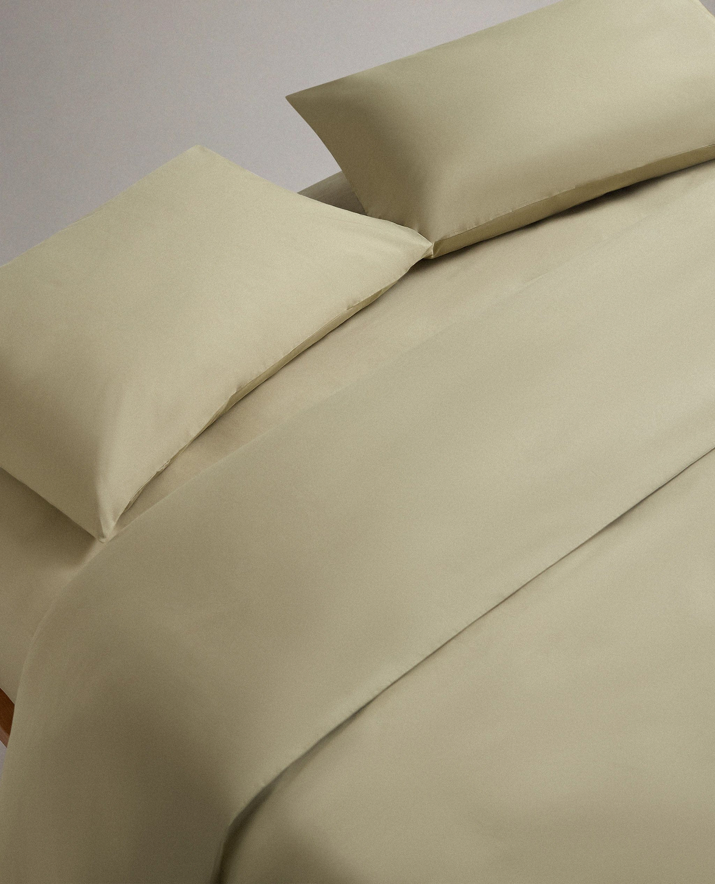 Image 1 of 4 showing bed made with Rise & Fall's Crisp & Cool organic cotton duvet set in sage.