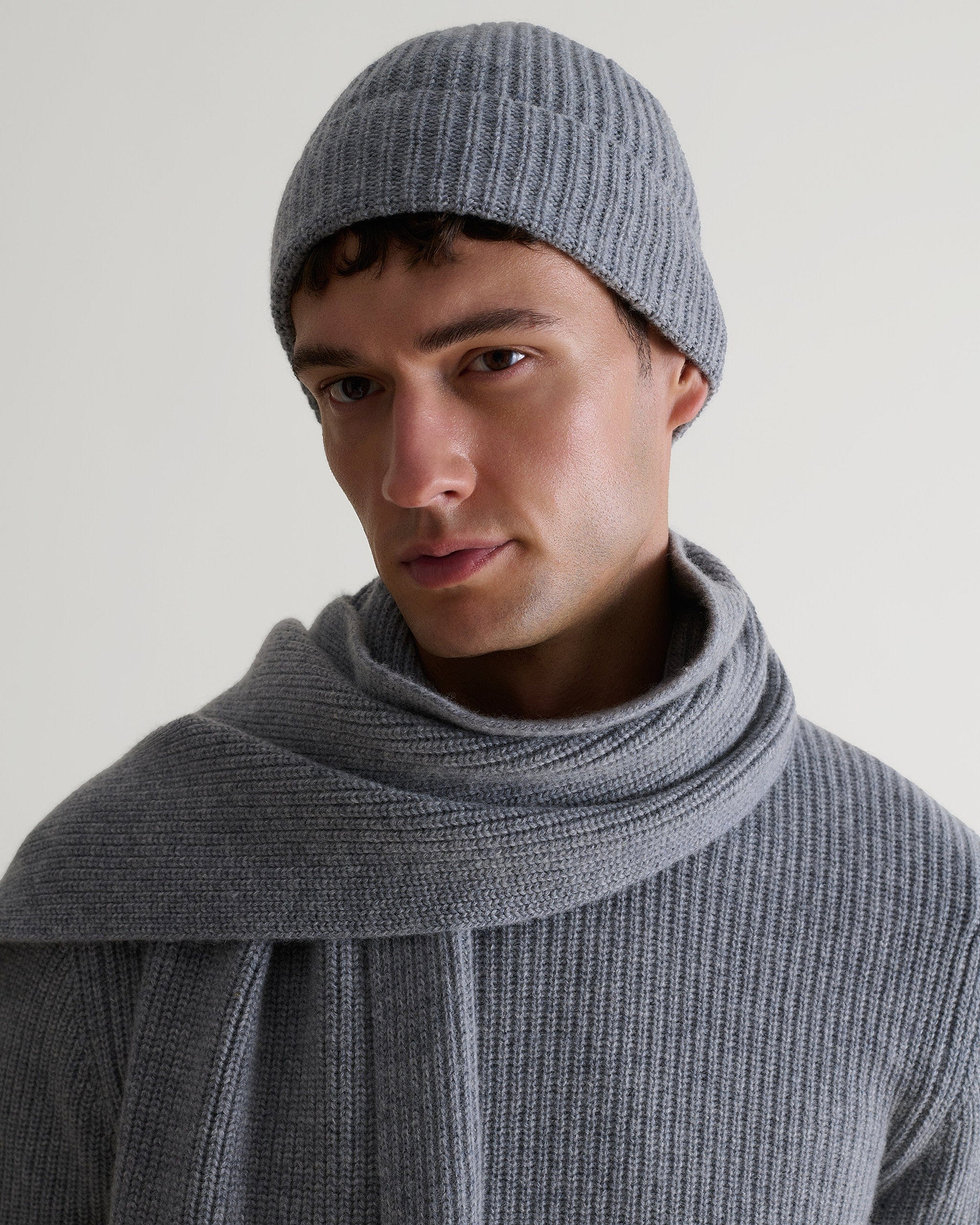 Image 1 of 4 showing man wearing Rise & Fall's Cashmere Merino Ribbed Knit Beanie in grey.