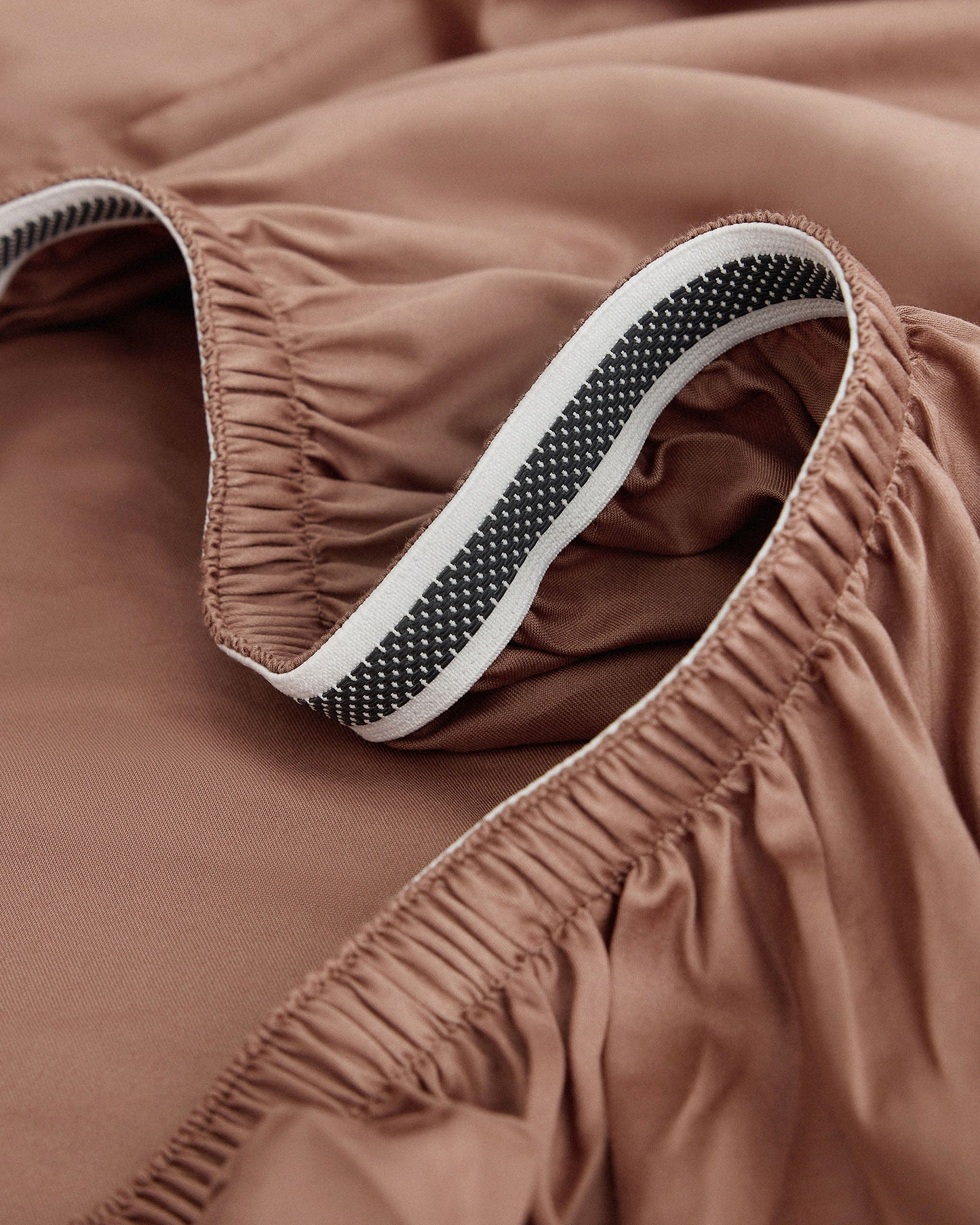 Image 2 of 5 showing Rise & Fall's Soft & Smooth sateen cotton deep fitted sheet in clay.
