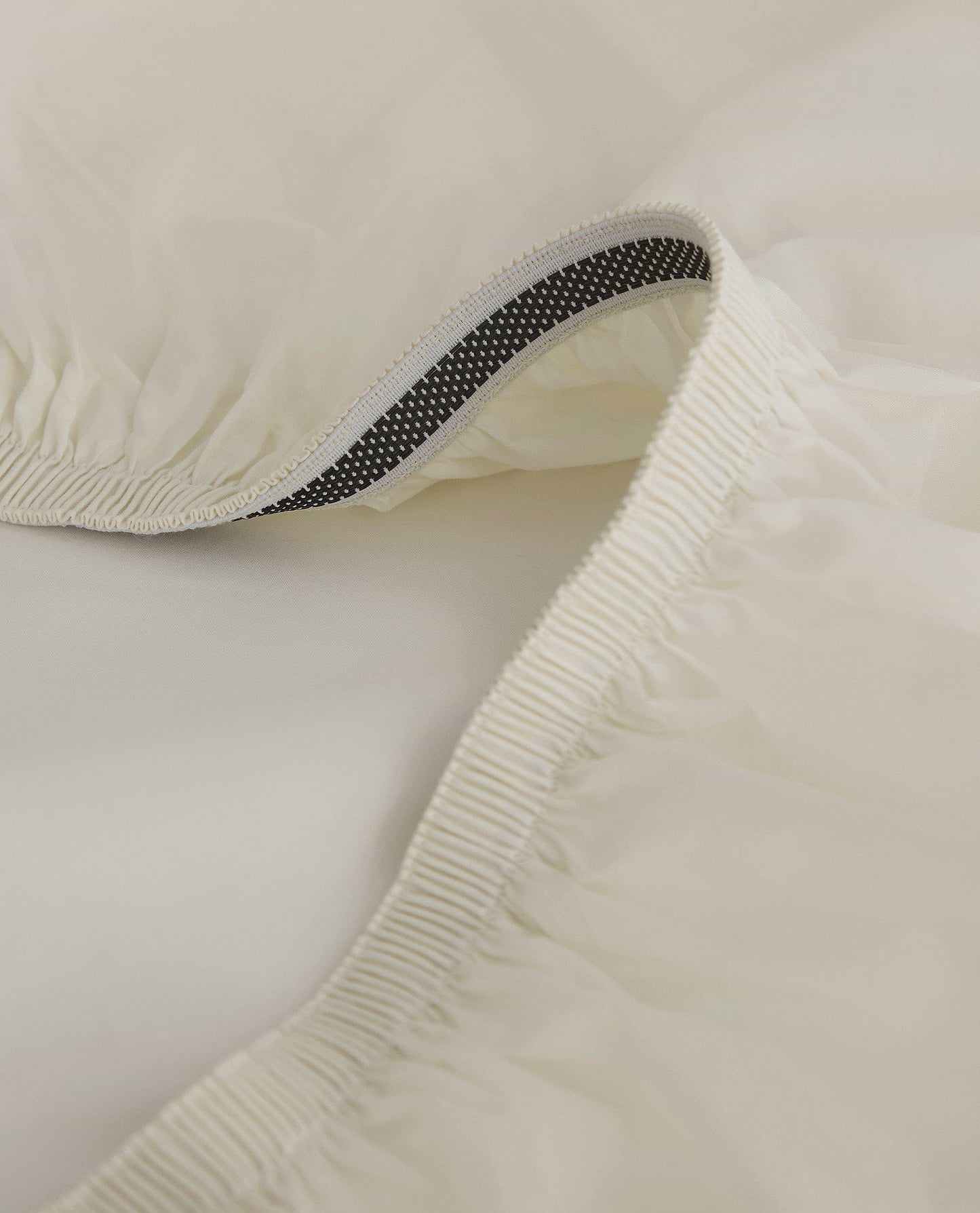Image 2 of 5 showing close up of Rise & Fall's Crisp & Cool organic cotton fitted sheet in cream.