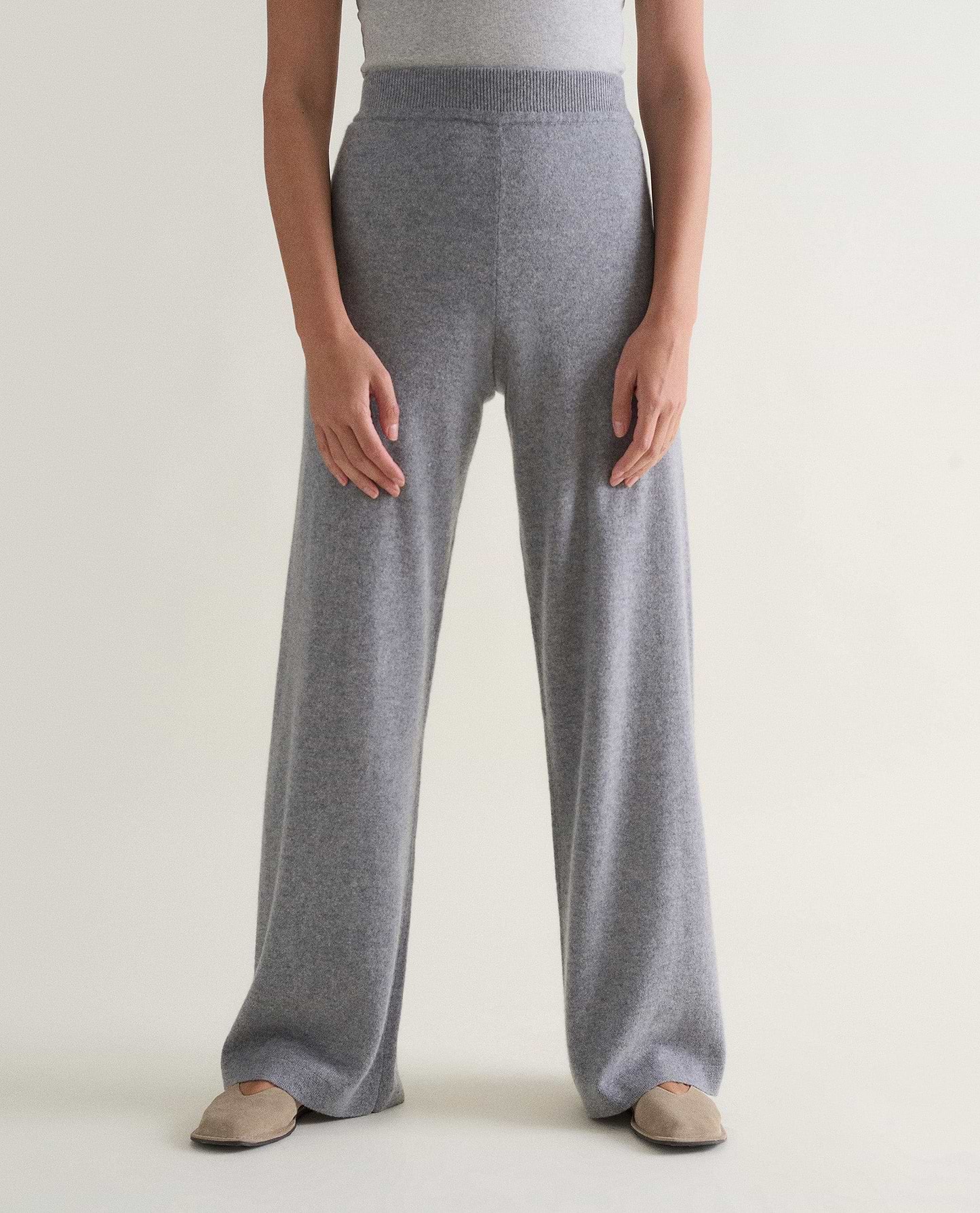 Image 3 of 3 showing woman wearing Rise & Fall's grey fine cashmere wide-leg trousers with white top.
