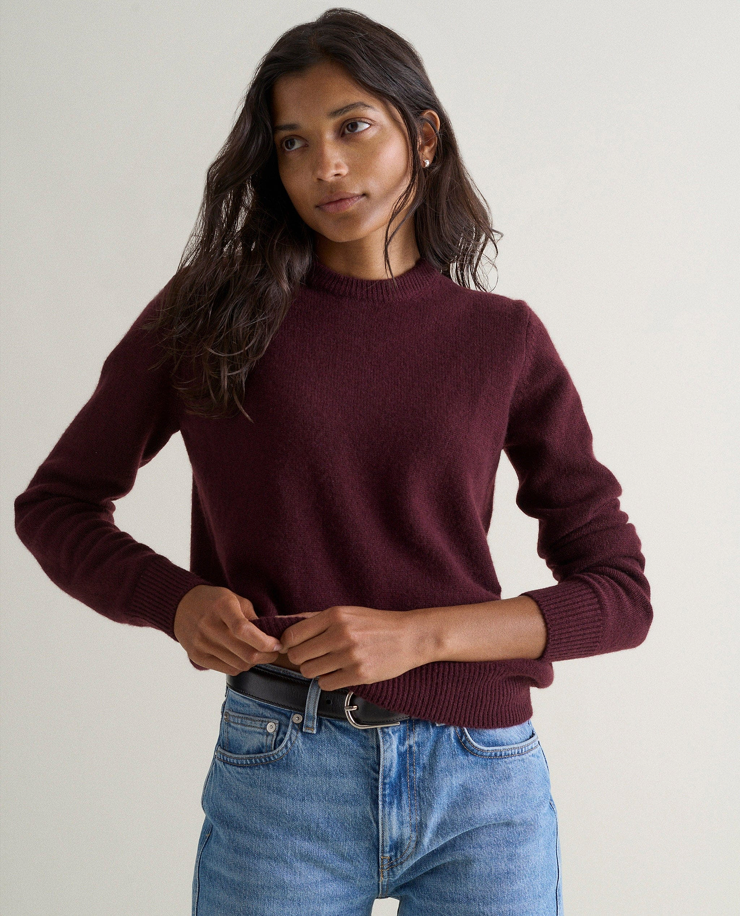 Image 3 of 3 showing woman wearing Rise & Fall's oxblood mid weight cashmere crew neck jumper with light blue jeans.