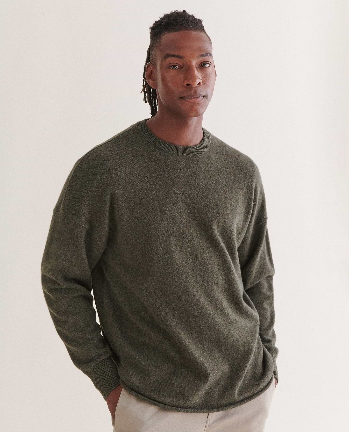 Image 3 of 5 showing man wearing Rise & Fall's finest cashmere mid-weight crew neck jumper in forest green with cream trousers.