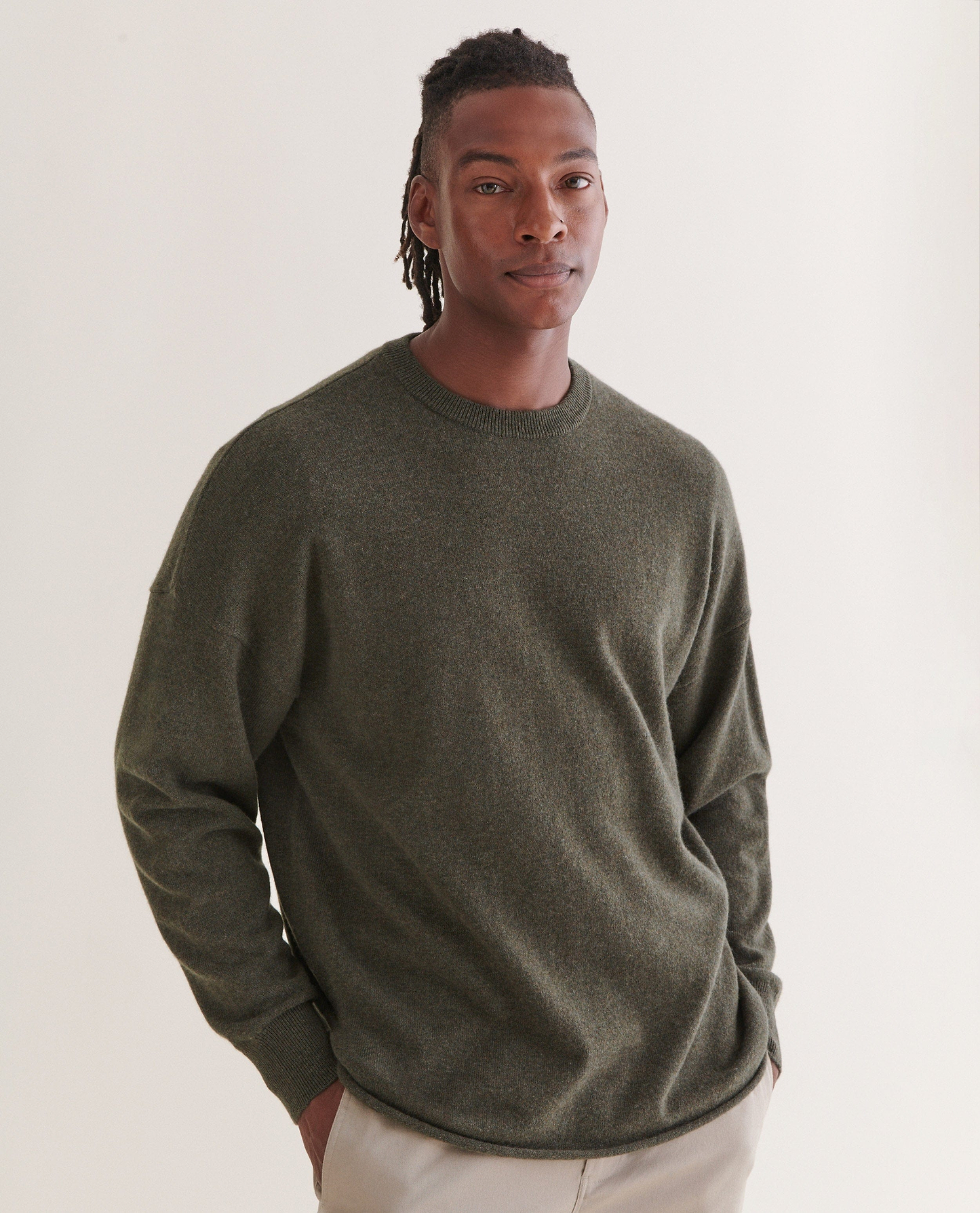 Image 3 of 5 showing man wearing Rise & Fall's finest cashmere mid-weight crew neck jumper in forest green with cream trousers.