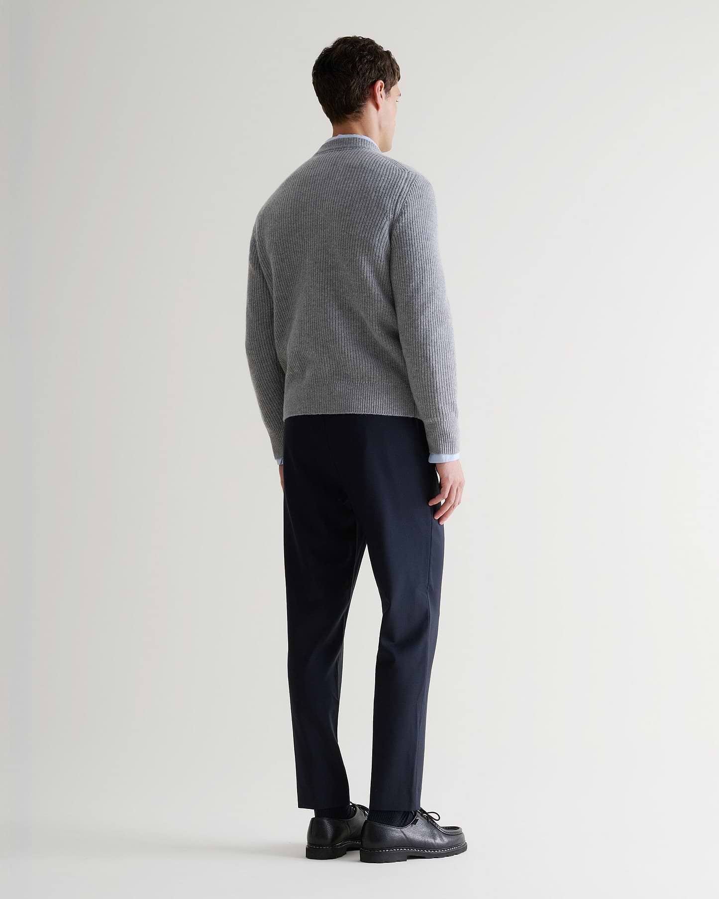Image 3 of 5 showing back of man wearing Rise & Fall's Cashmere Merino Fishermans Rib Crew Neck Jumper in grey.
