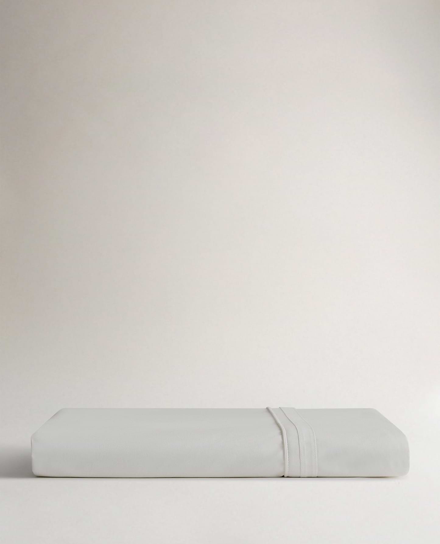 Image 3 of 5 showing Rise & Fall's Crisp & Cool organic percale cotton flat bed sheet in white tailored border.
