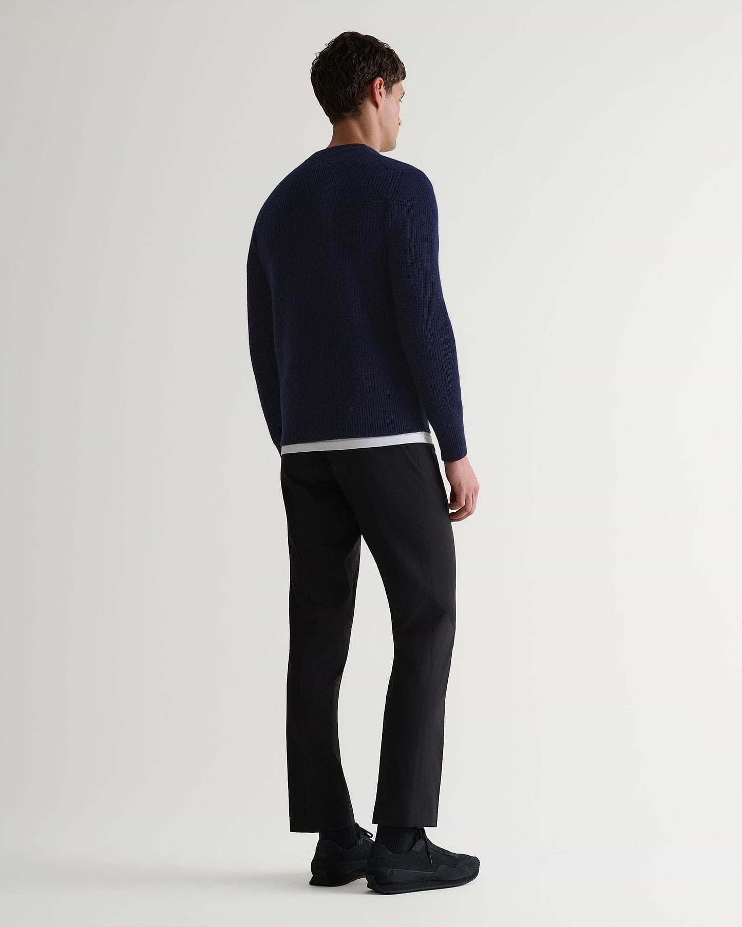 Image 3 of 6 showing back of man wearing Rise & Fall's Cashmere Merino Fishermans Rib Crew Neck Jumper in navy.