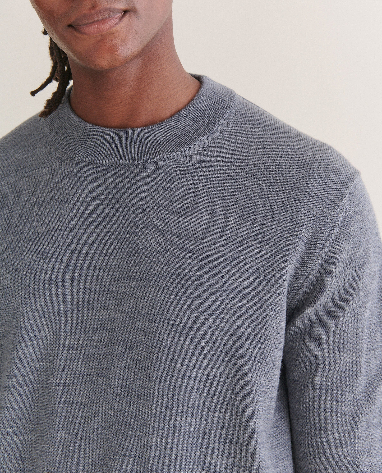 Image 4 of 4 showing close up of man wearing Rise & Fall's merino mid-weight crew neck jumper in grey.
