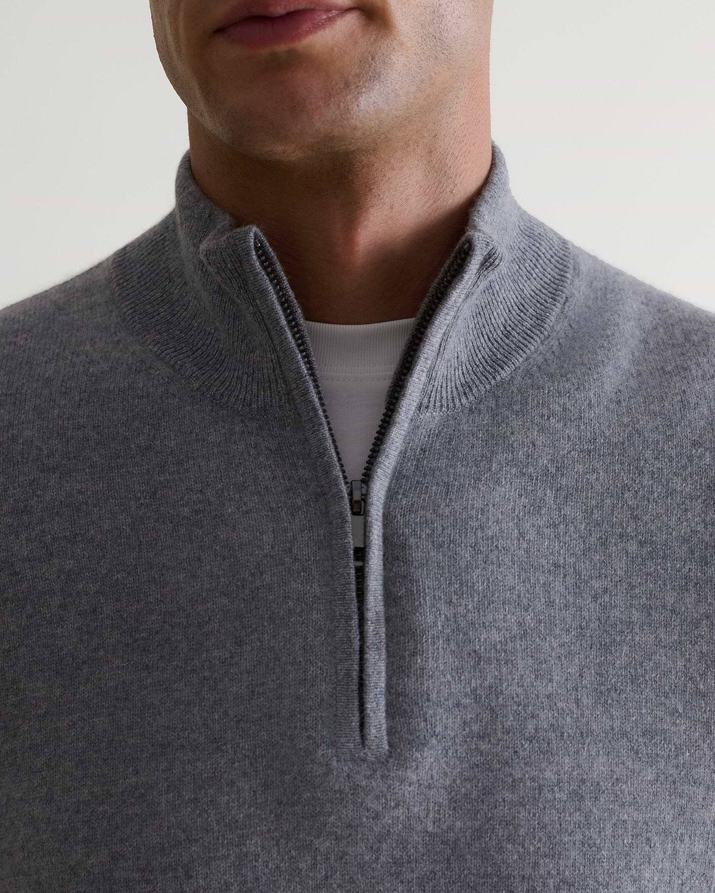Image 4 of 5 showing man wearing Rise & Fall's fine cashmere 1/4 zip jumper, grey, close-up.