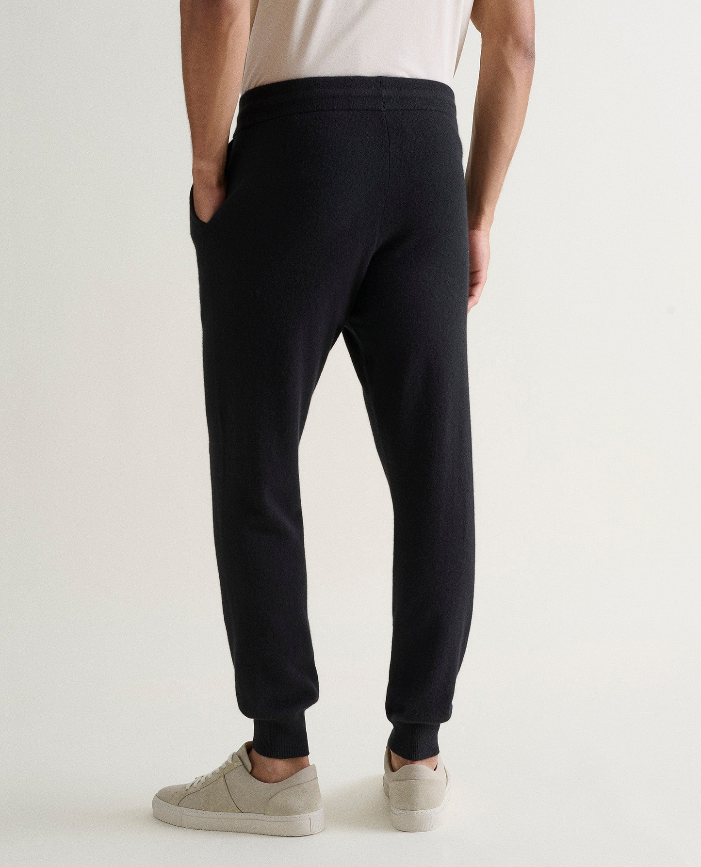 Image 4 of 5 showing man wearing Rise & Fall's fine cashmere joggers, black, back view.