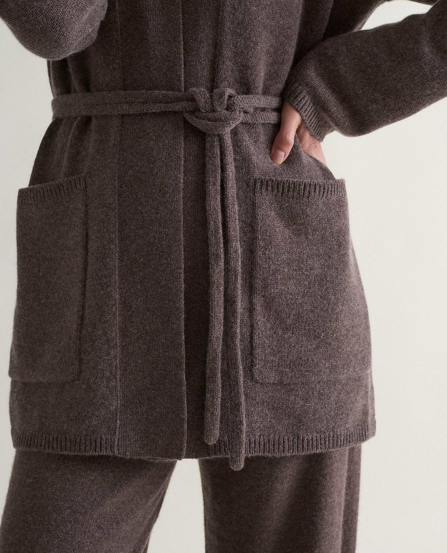 Image 4 of 6 showing close up of Rise & Fall's brown cashmere merino belted cardigan with matching cashmere trousers.