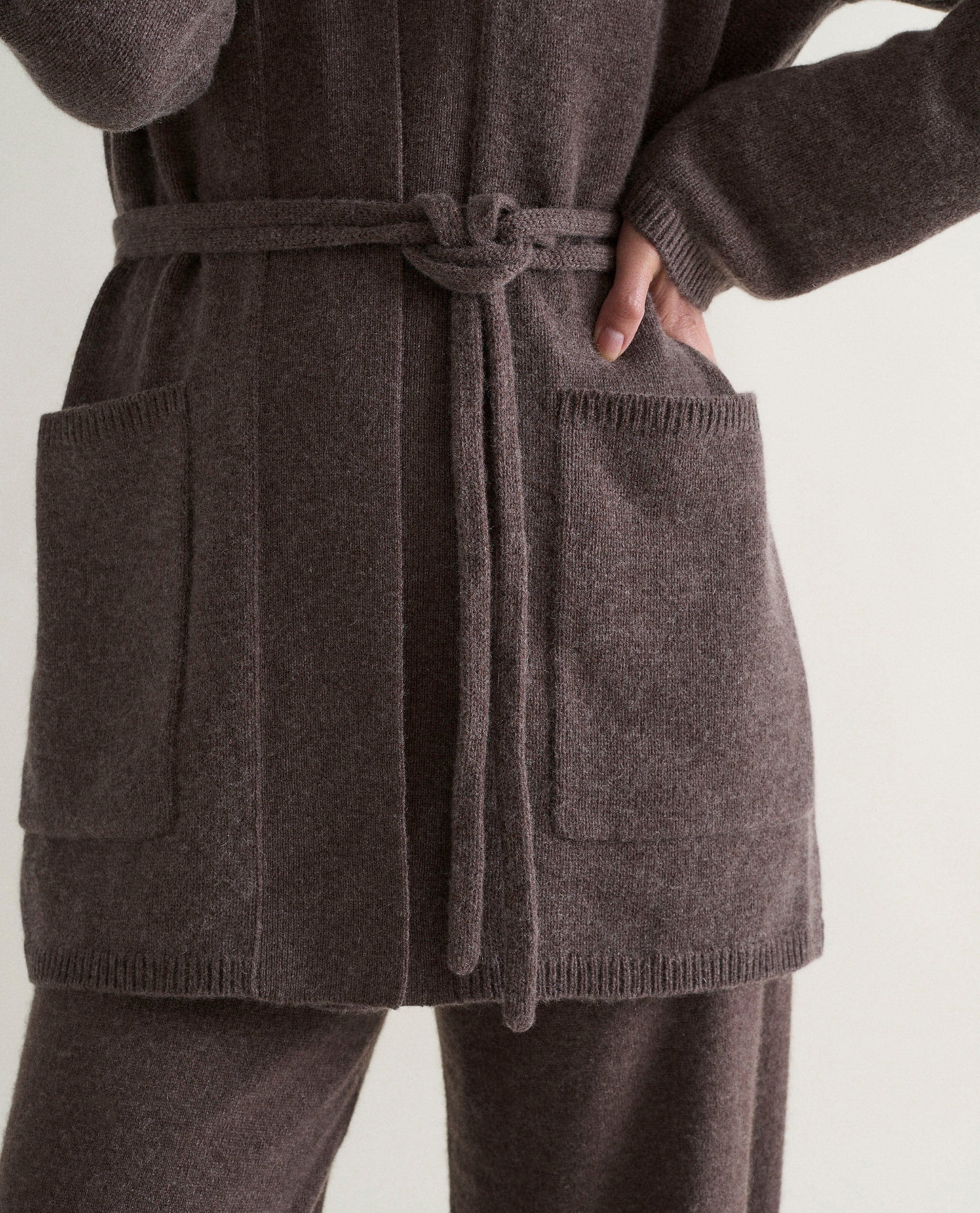 Image 4 of 6 showing close up of Rise & Fall's brown cashmere merino belted cardigan with matching cashmere trousers.