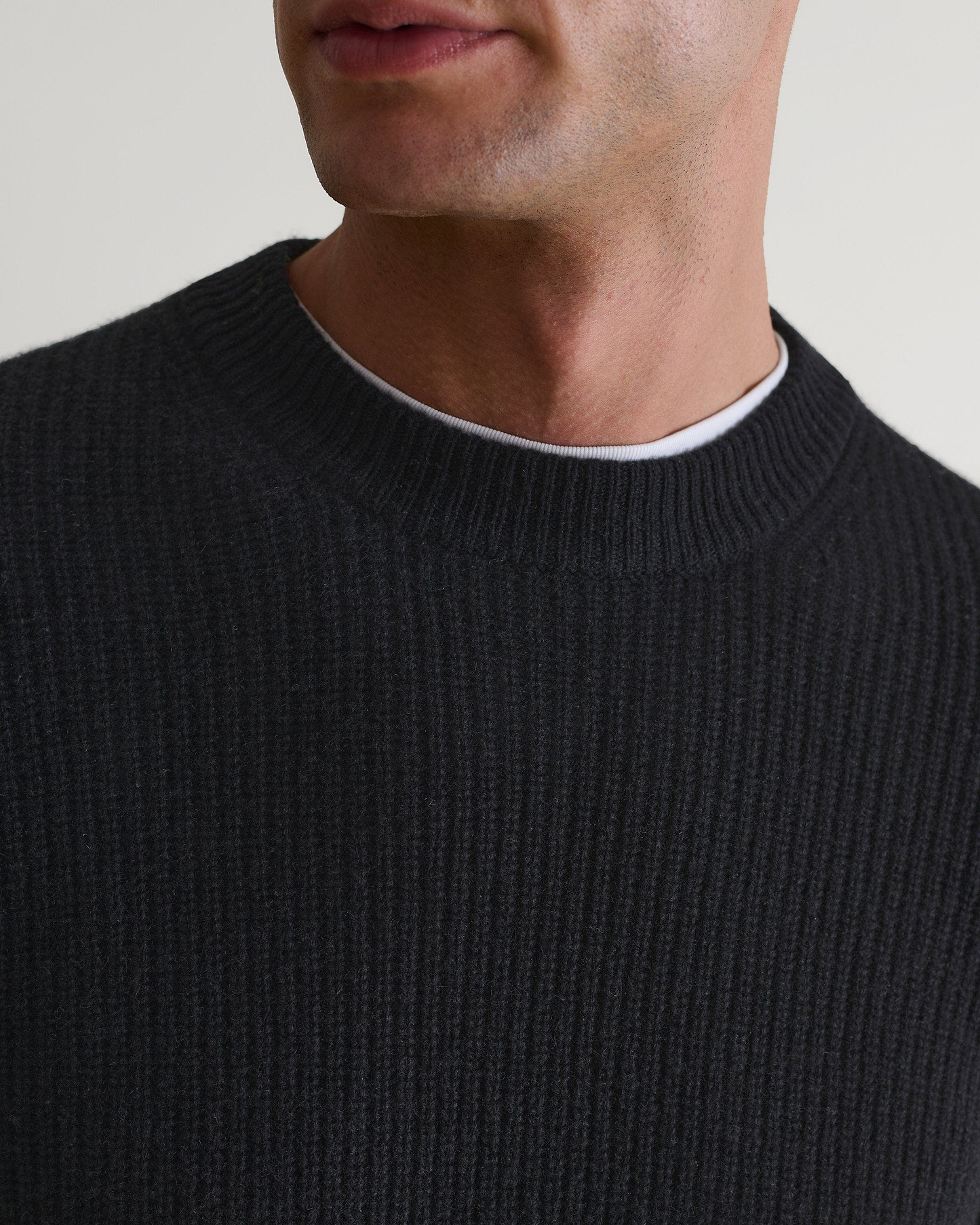Image 5 of 5 showing close up of man wearing Rise & Fall's Cashmere Merino Fishermans Rib Crew Neck Jumper in black.