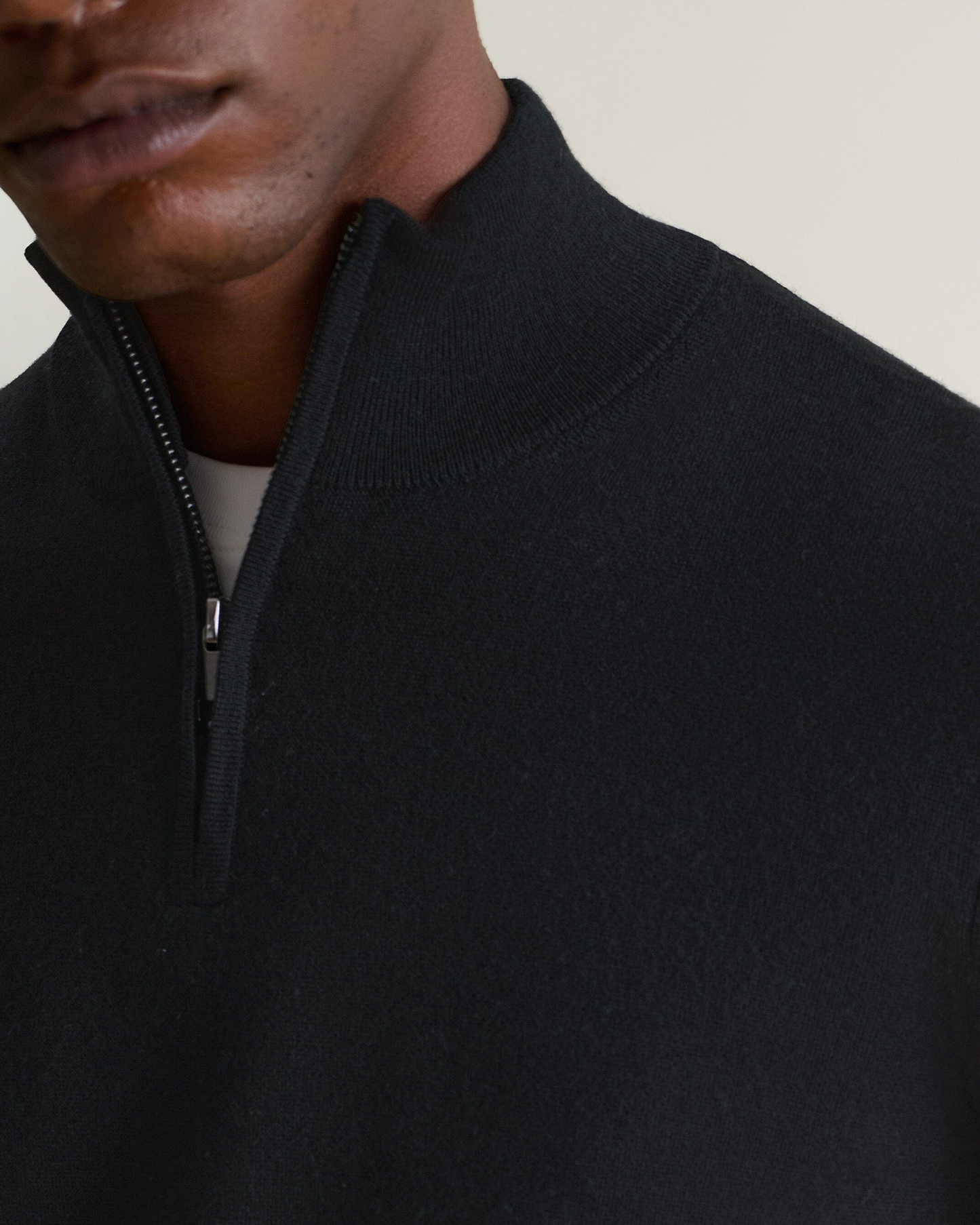 Image 5 of 5 showing man wearing Rise & Fall's fine cashmere 1/4 zip jumper, black, close up.