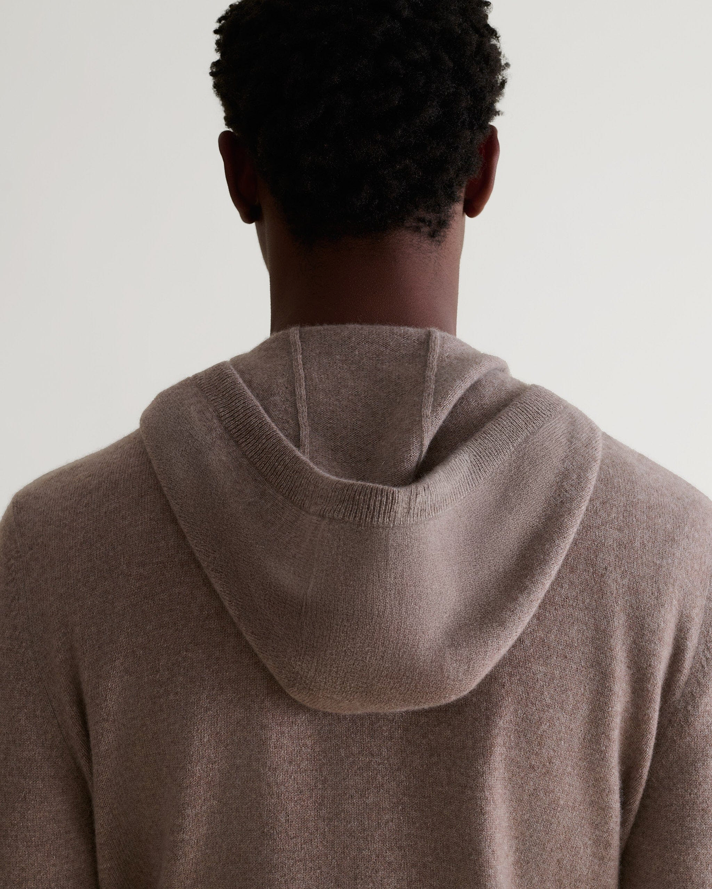 Image 5 of 5 showing man wearing Rise & Fall's fine cashmere zip hoodie, toast, back view.