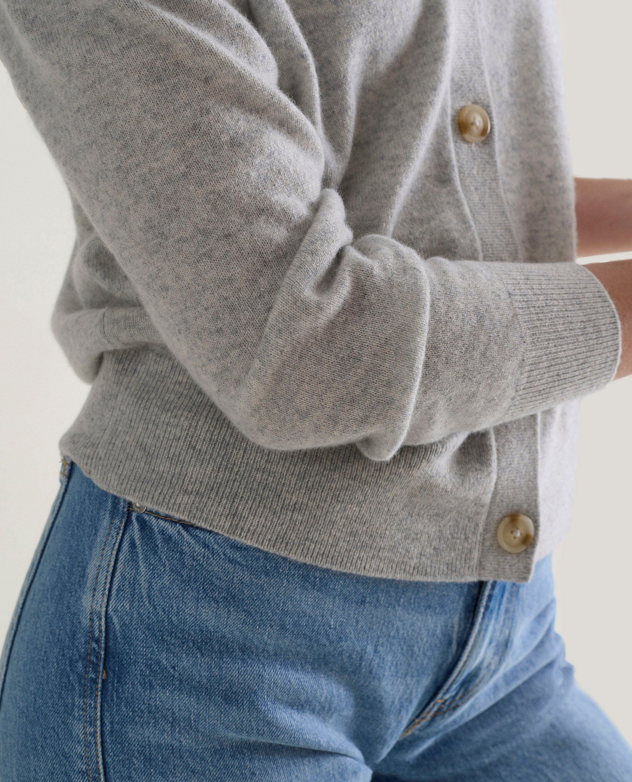 Image 5 of 5 showing side view of woman wearing Rise & Fall's grey fine cashmere v-neck cardigan.
