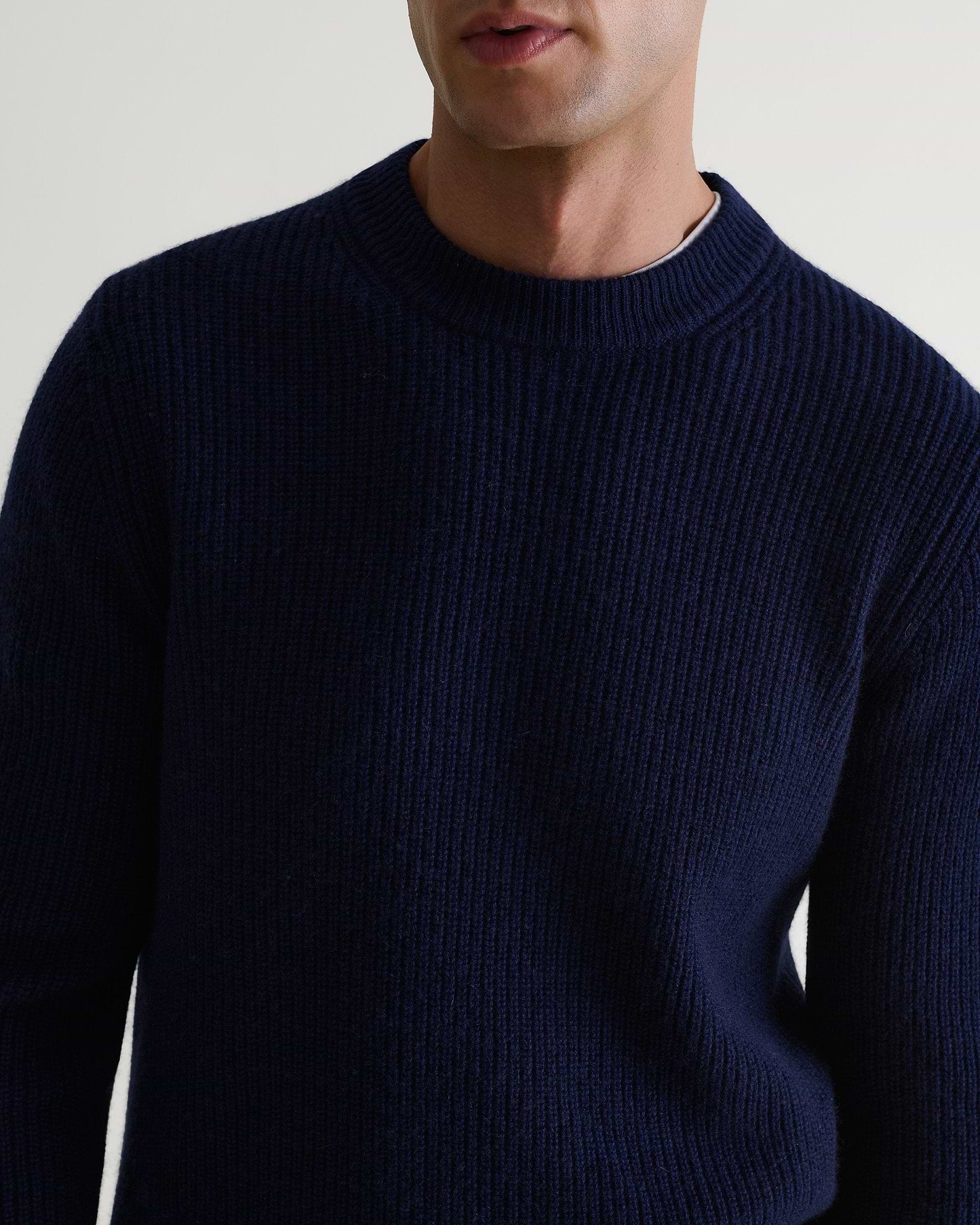 Image 5 of 6 showing close up of man wearing Rise & Fall's Cashmere Merino Fishermans Rib Crew Neck Jumper in navy.