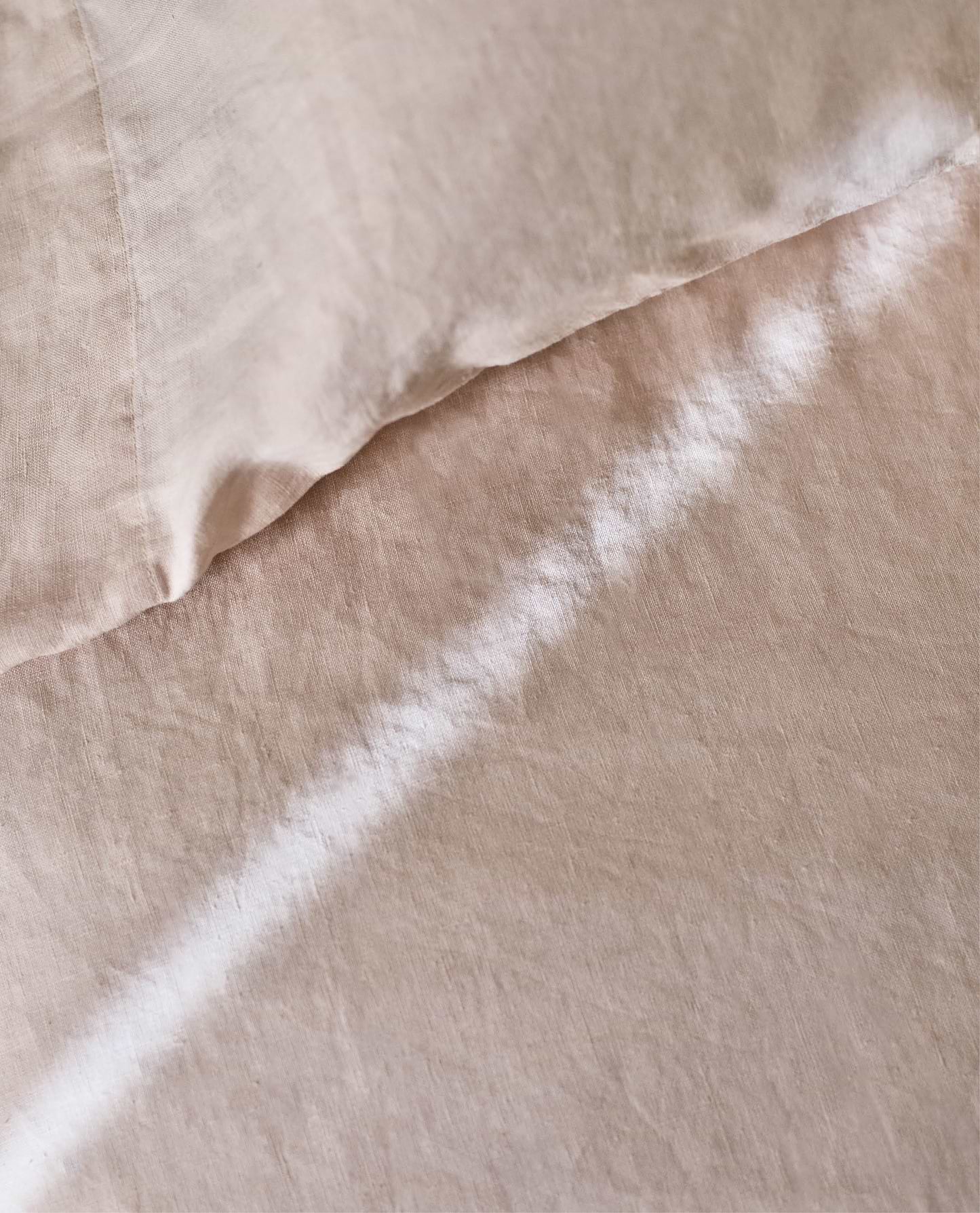 Image 5 of 6 showing Rise & Fall's Relaxed & Refined linen flat sheet in pale peach.