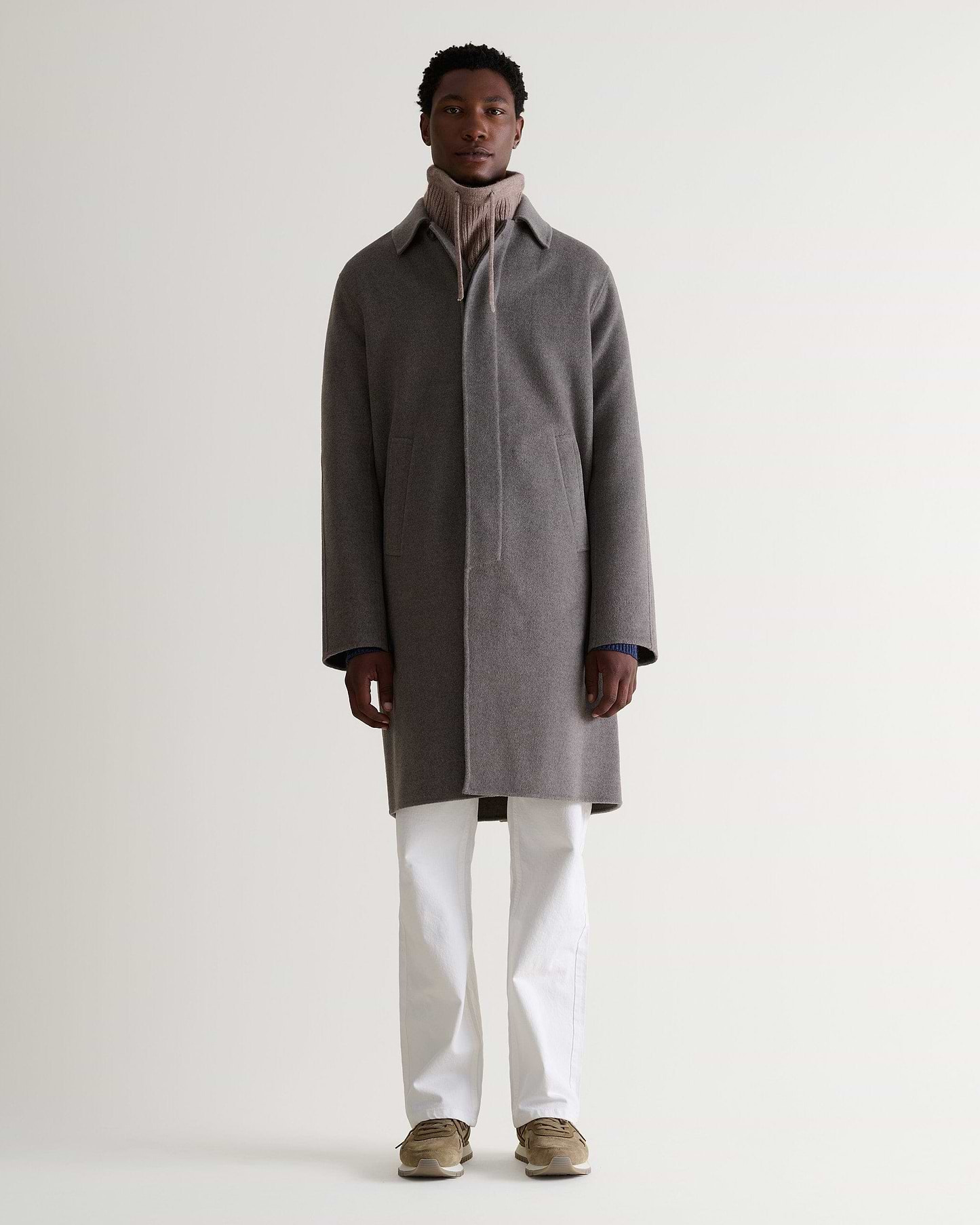 Full portrait view of man wearing toast cashmere merino drawstring snood with grey wool overcoat