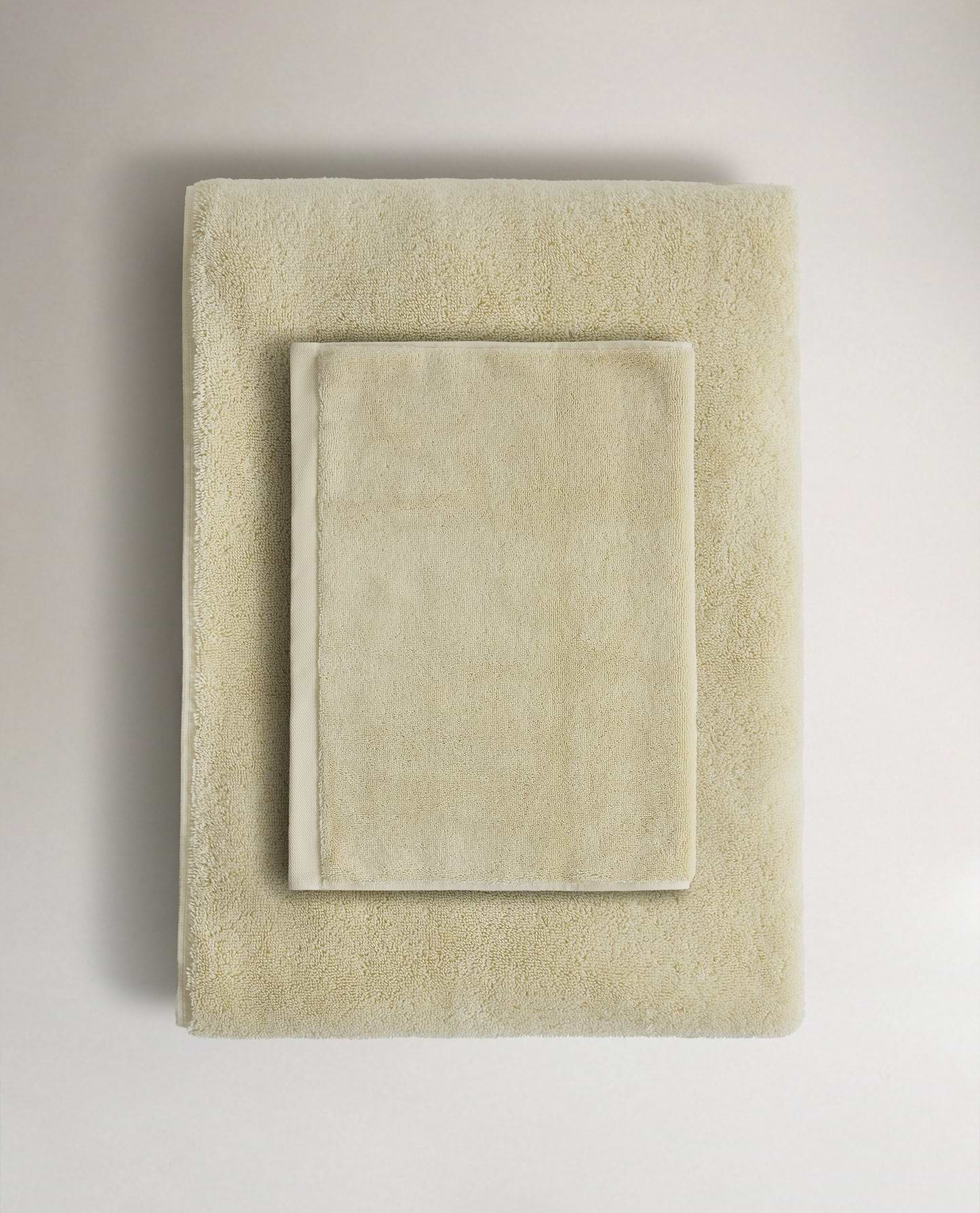 Rise & Fall's buttermilk Turkish cotton hand towel lying on top of matching bath towel