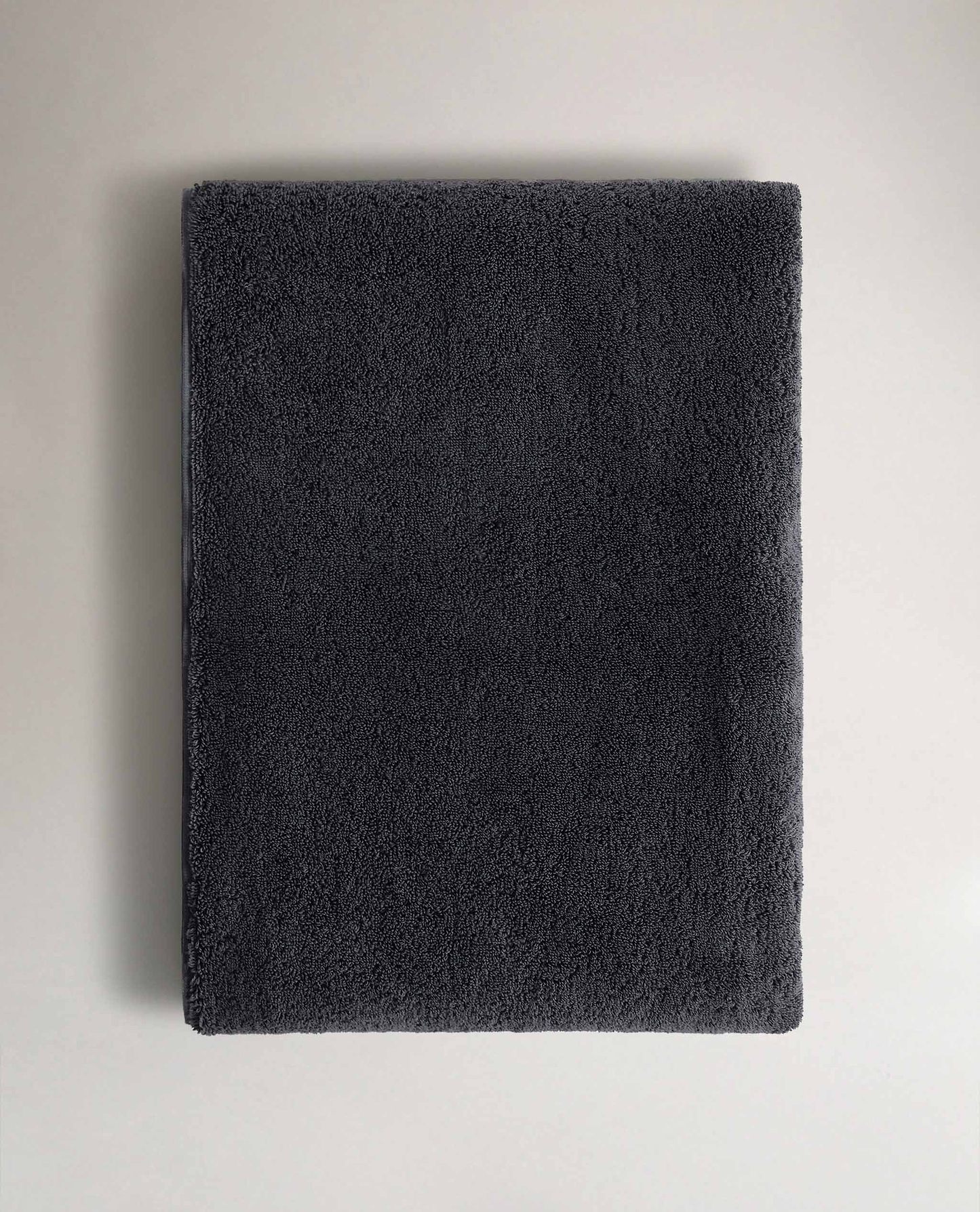 Rise & Fall's charcoal Turkish cotton hand towel lying on top of matching bath towel