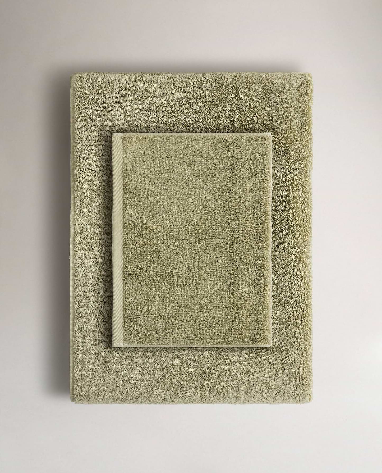 Rise & Fall's sage Turkish cotton hand towel lying on top of matching bath towel
