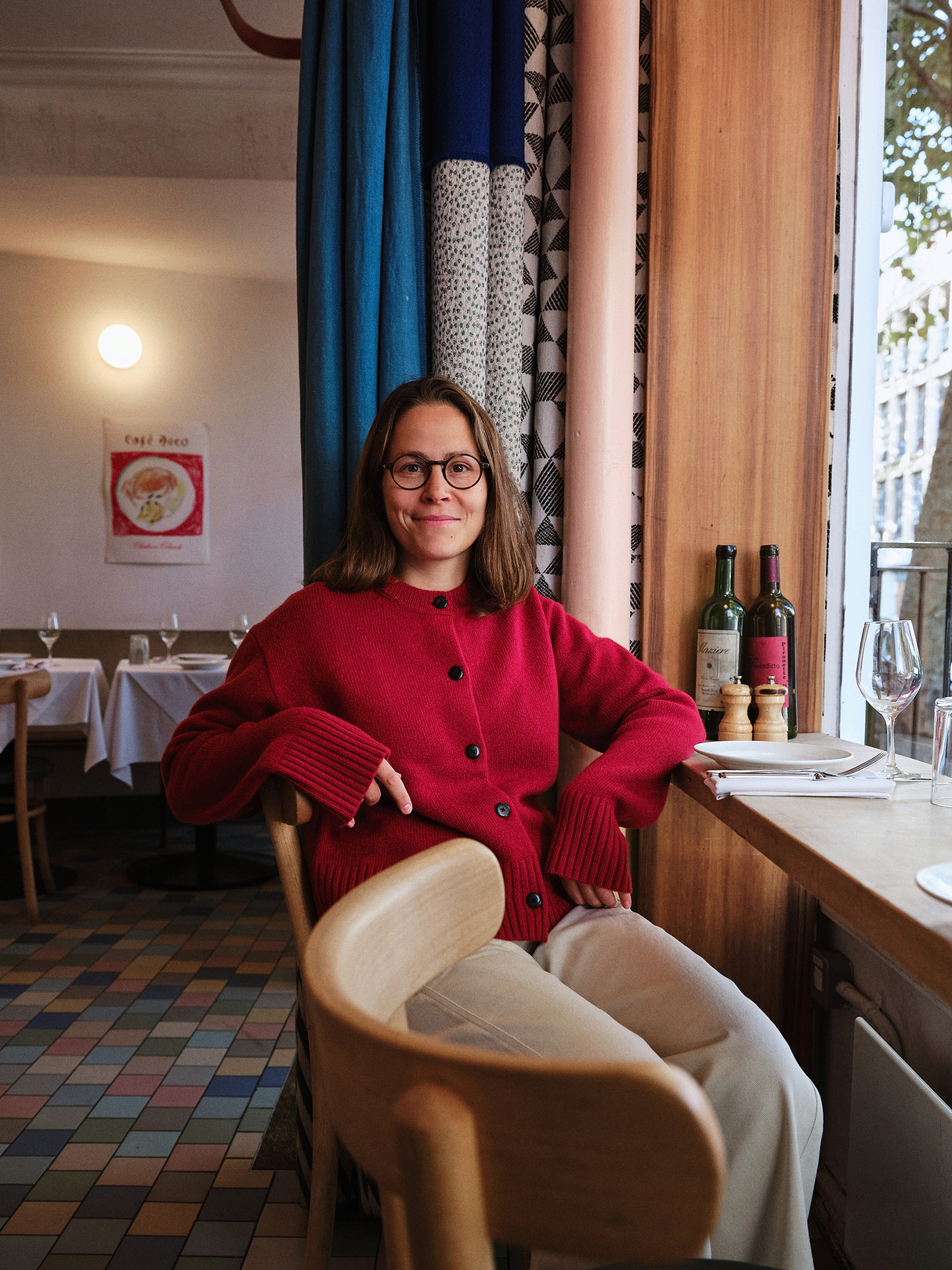 Anna Tobias wears Rise & Fall's red wool cardigan and barrel leg jeans/