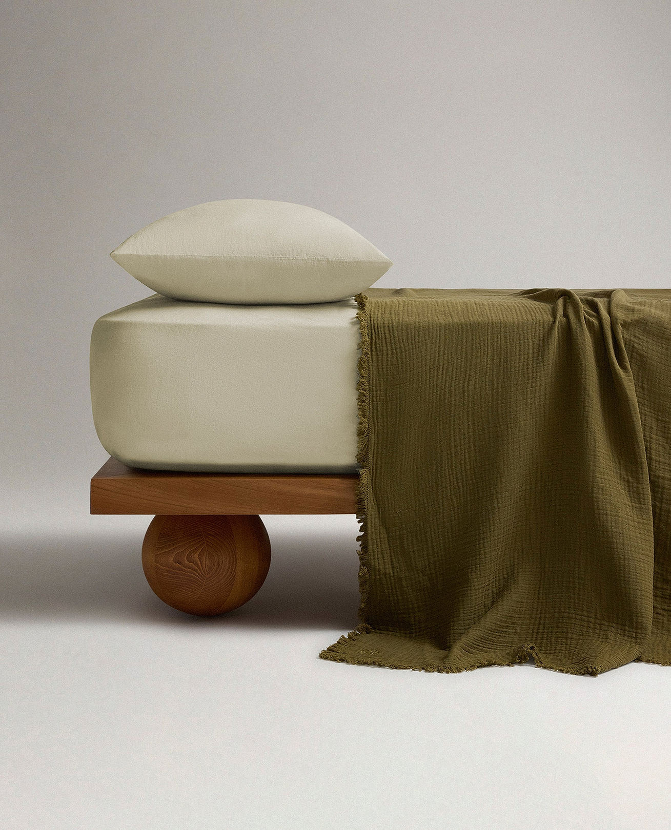Bed made with cotton and linen bedding. 