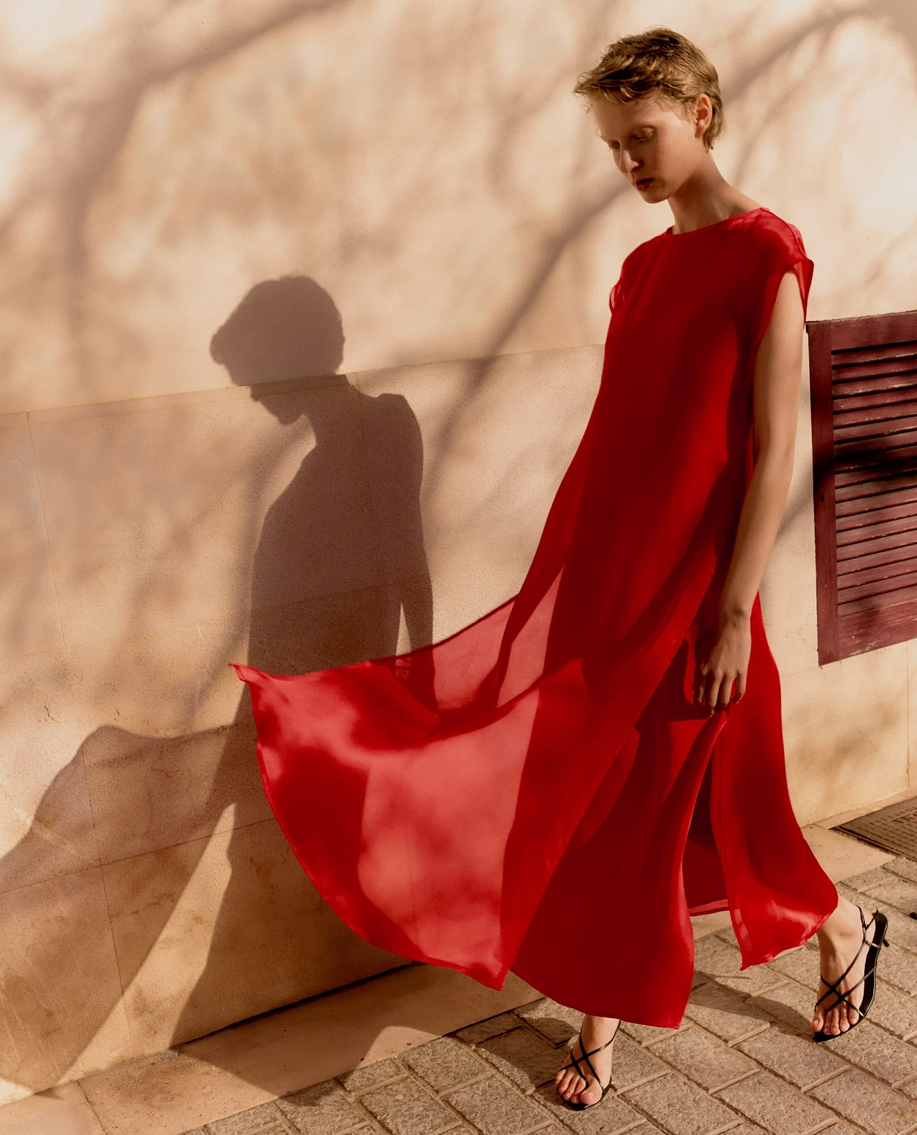 Woman wears Rise & Fall's Red Silk Organza Layered Maxi Dress.