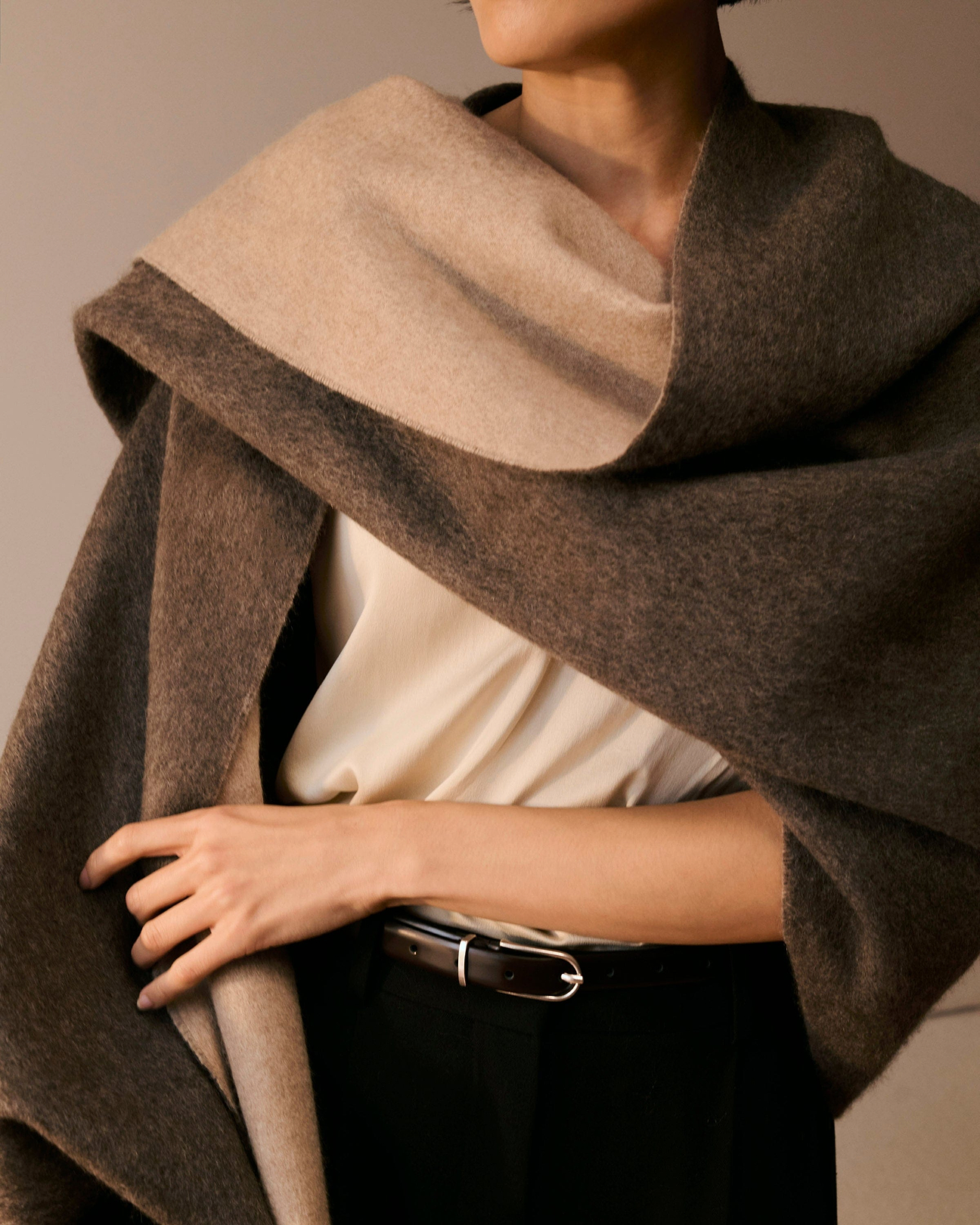 A 100% cashmere double sided wrap around a woman's shoulders.