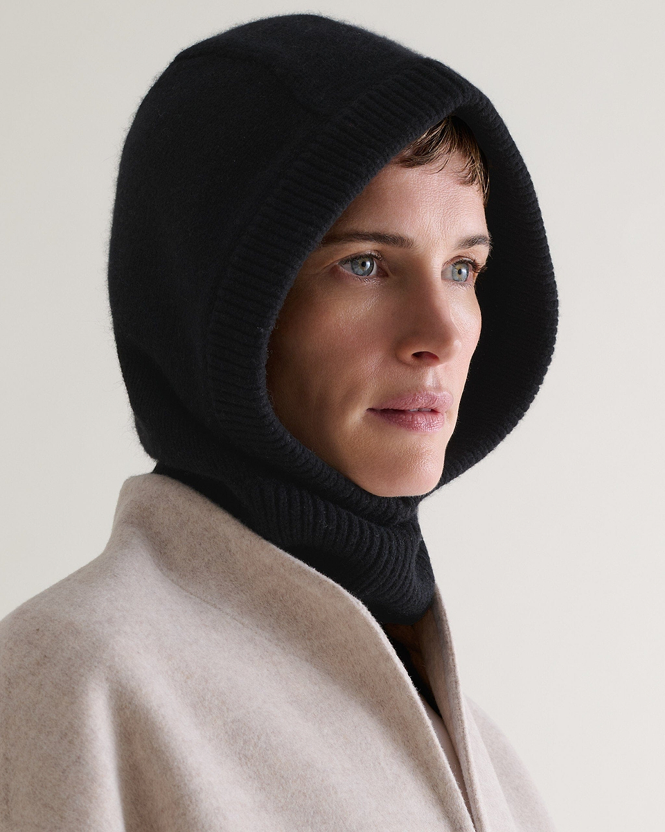 Image 1 of 2 showing woman wearing Rise & Fall's black Cashmere Merino Knitted Hood.