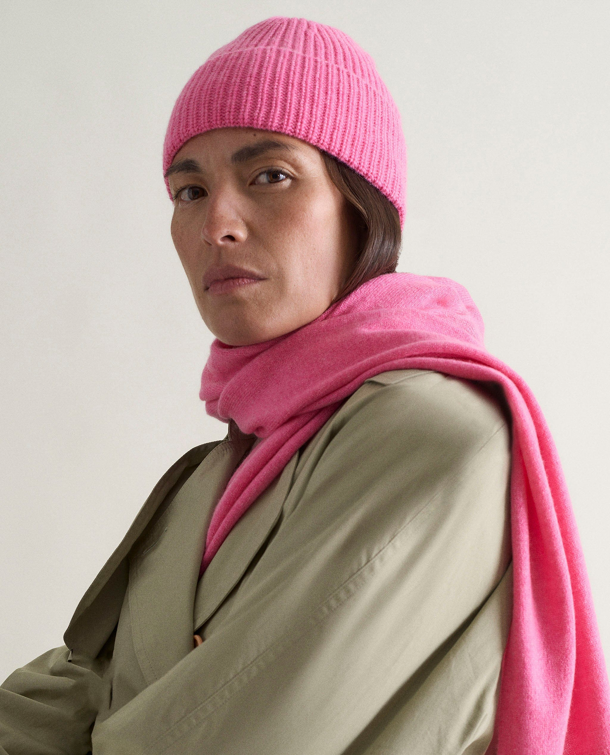 Image 1 of 2 showing woman wearing Rise & Fall's Cashmere Merino Ribbed Knit Beanie in pink.