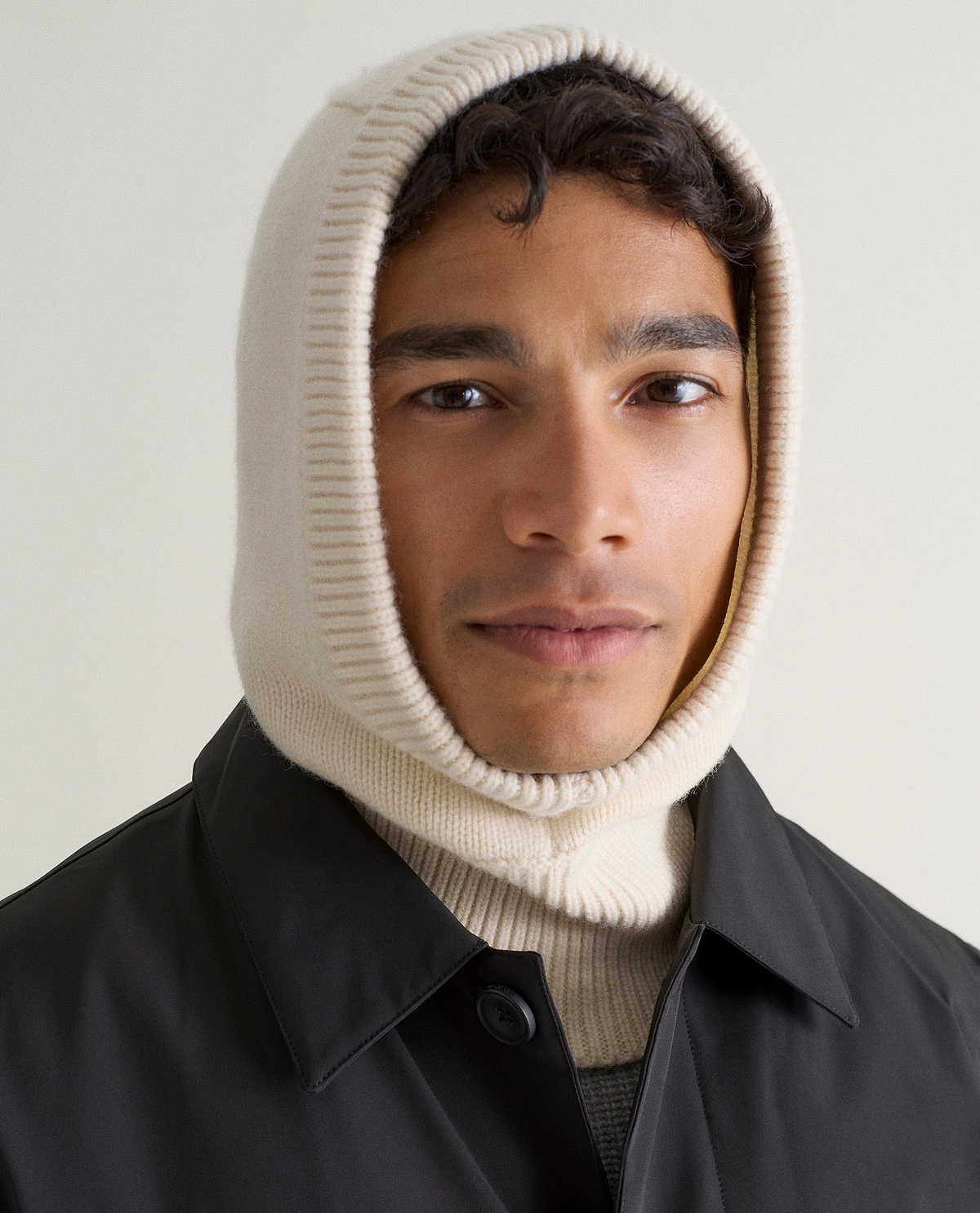 Image 1 of 3 showing man wearing Rise & Fall's cream Cashmere Merino Knitted Hood.