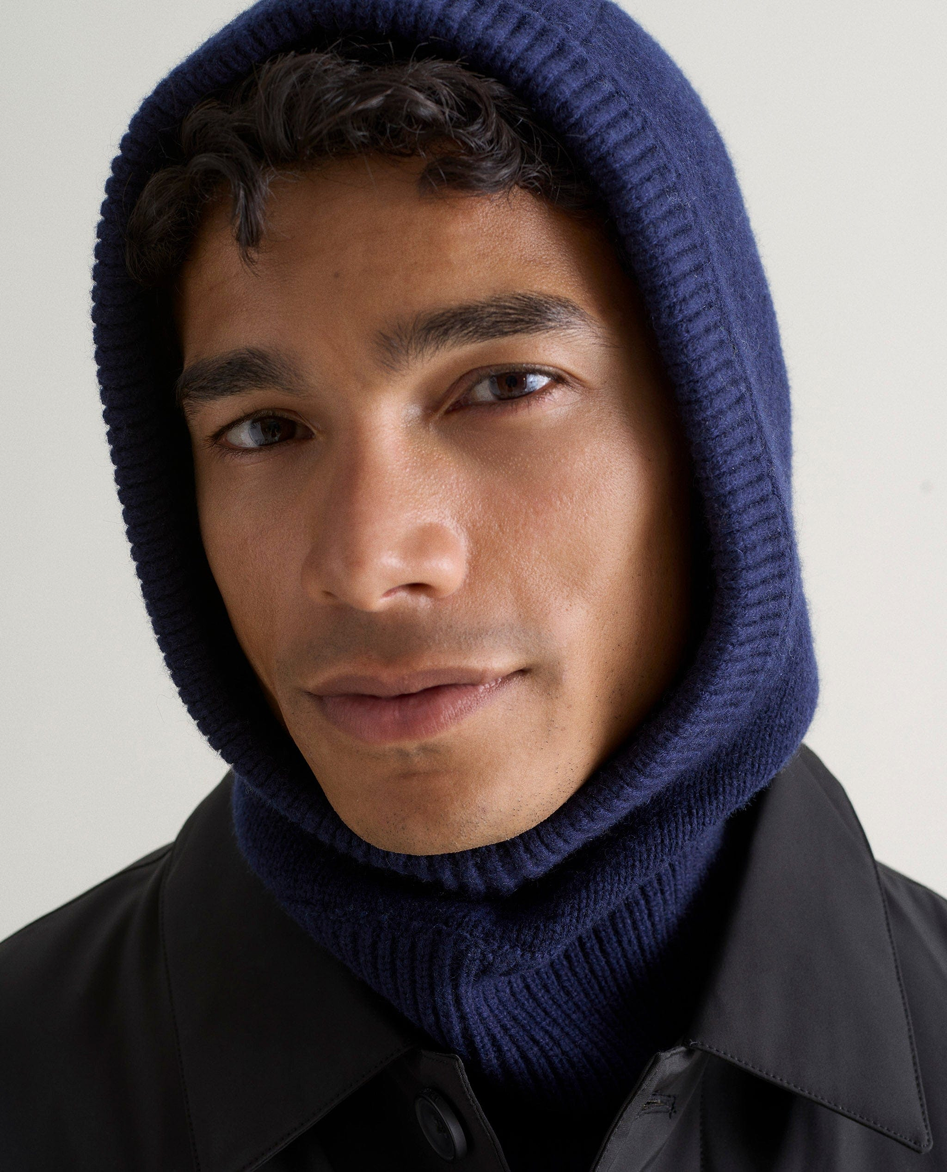 Image 1 of 3 showing man wearing Rise & Fall's navy Cashmere Merino Knitted Hood.