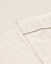 Image 1 of 3 showing Rise & Fall's Soft & Smooth organic sateen cotton flat sheet in buttermilk stripe.