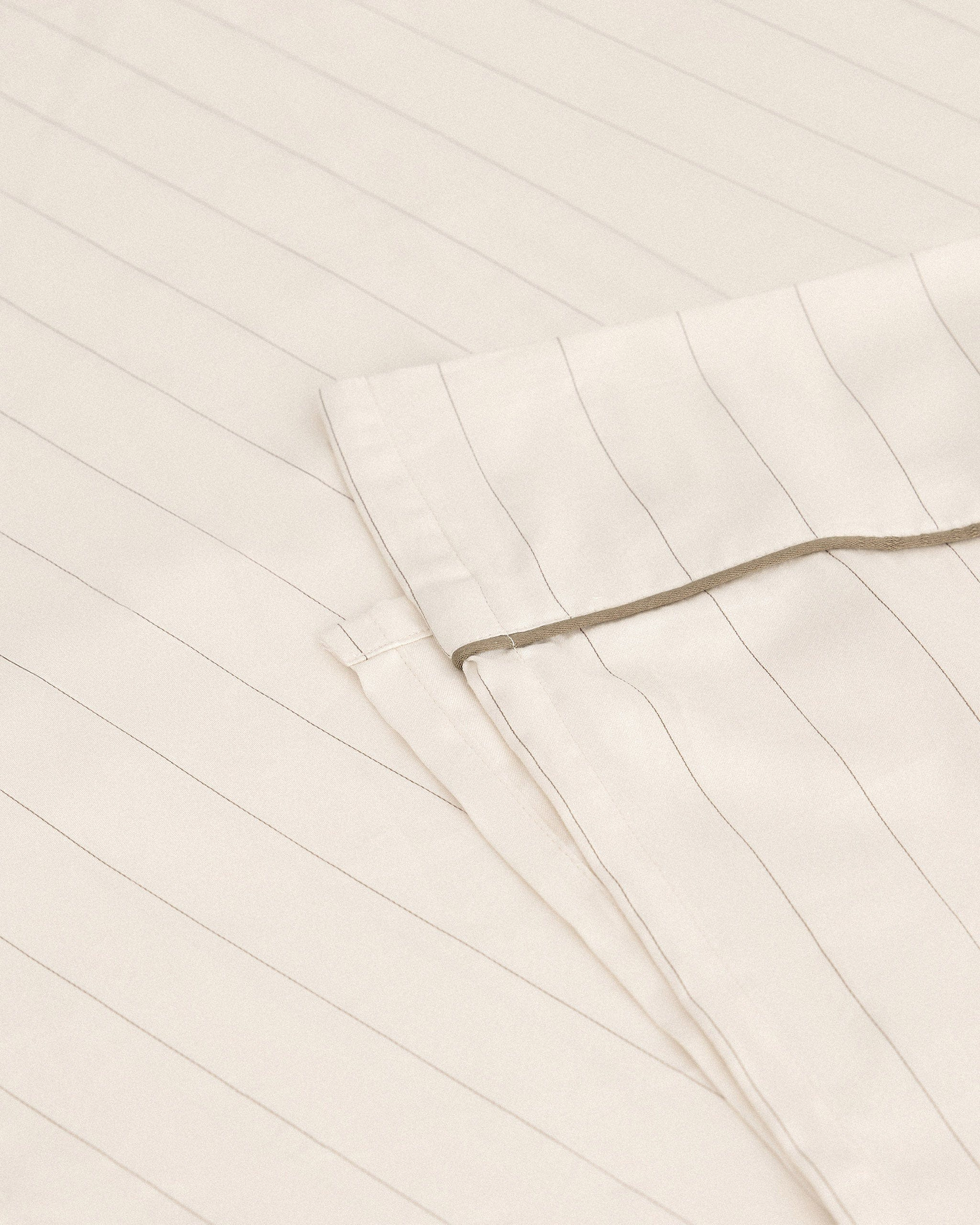 Image 1 of 3 showing Rise & Fall's Soft & Smooth organic sateen cotton flat sheet in buttermilk stripe.