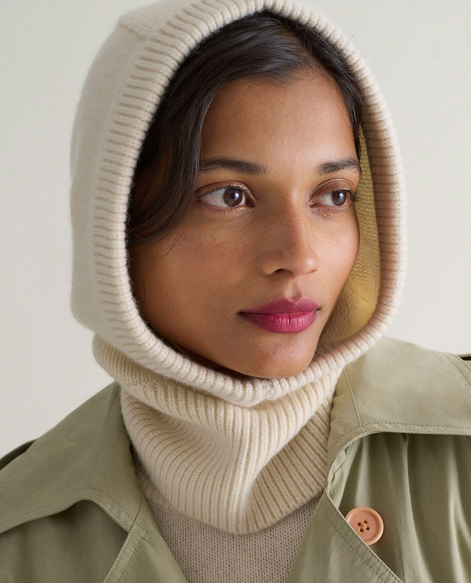 Image 1 of 3 showing woman wearing Rise & Fall's cream Cashmere Merino Knitted Hood.