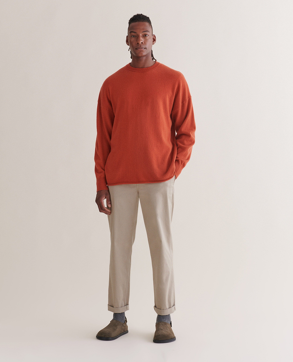 Image 1 of 4 showing man wearing Rise & Fall's finest cashmere sweatshirt in rust with stone-coloured trousers and brown suede shoes.