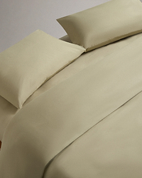 Image 1 of 4 showing bed made with Rise & Fall's Crisp & Cool organic cotton duvet set in sage.