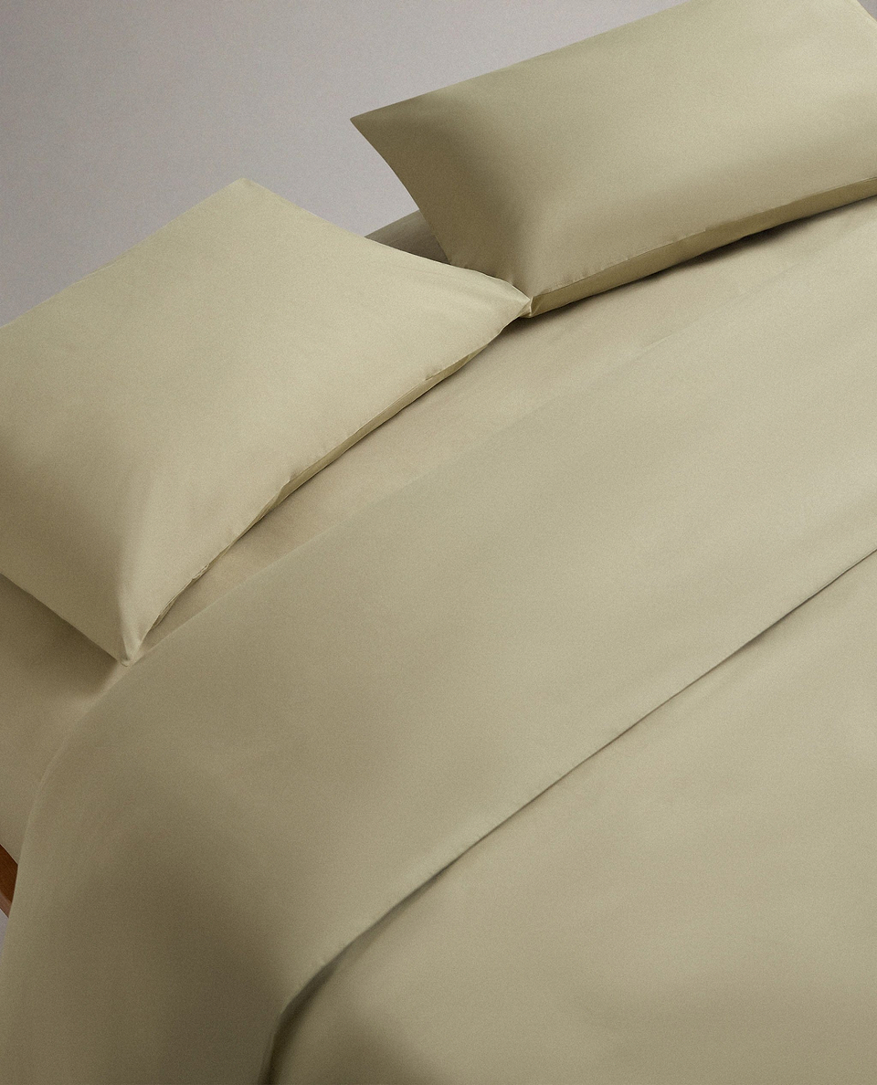 Image 1 of 4 showing bed made with Rise & Fall's Crisp & Cool organic cotton duvet set in sage.