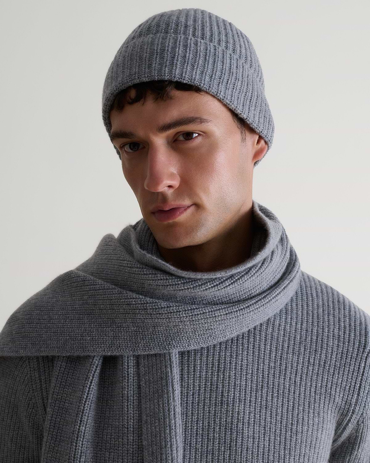 Image 1 of 4 showing man wearing Rise & Fall's Cashmere Merino Ribbed Knit Beanie in grey.